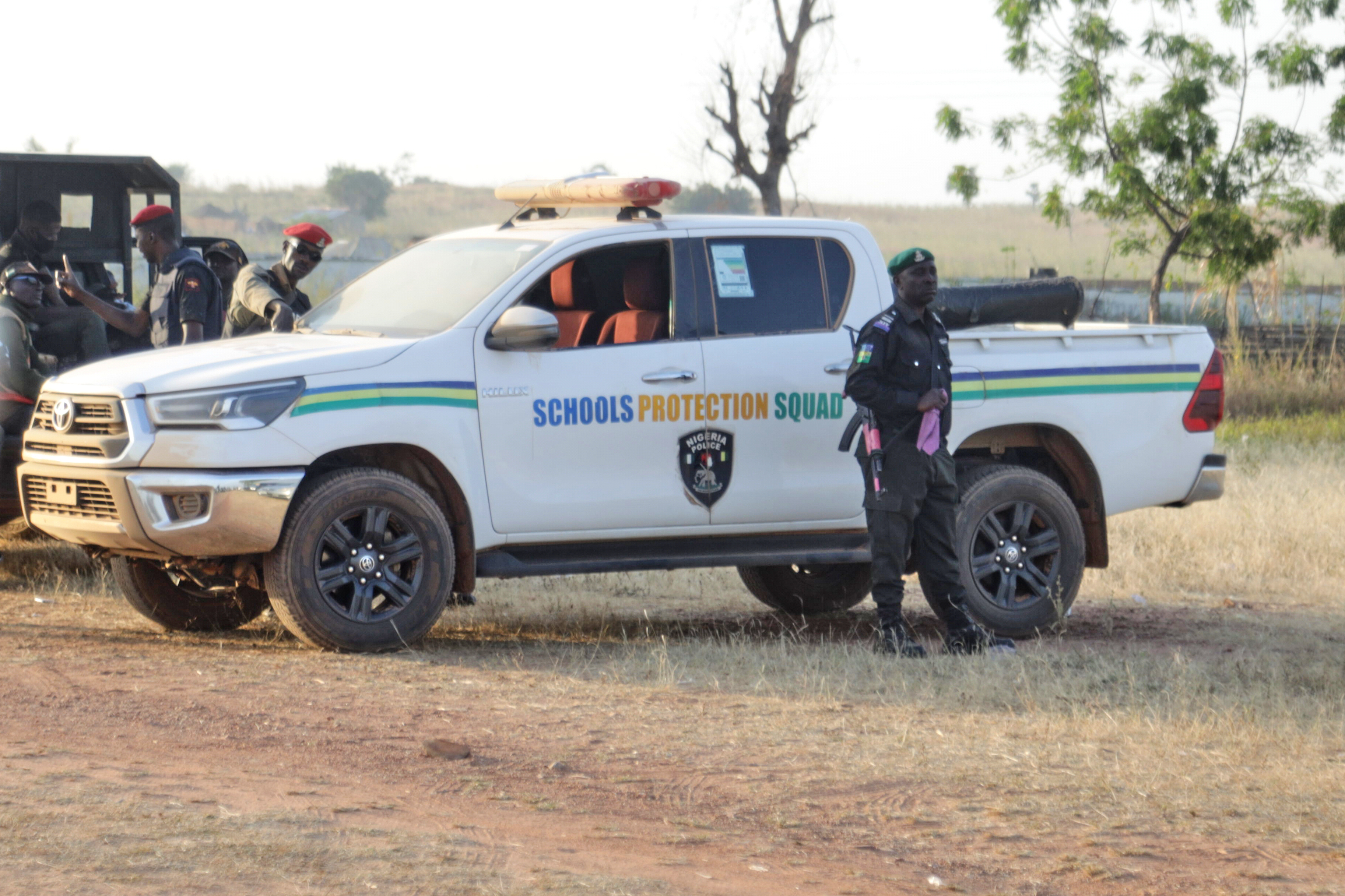 Police officers stand guard outside the school where children were kidnapped by gunmen in Kebbi, Nigeria