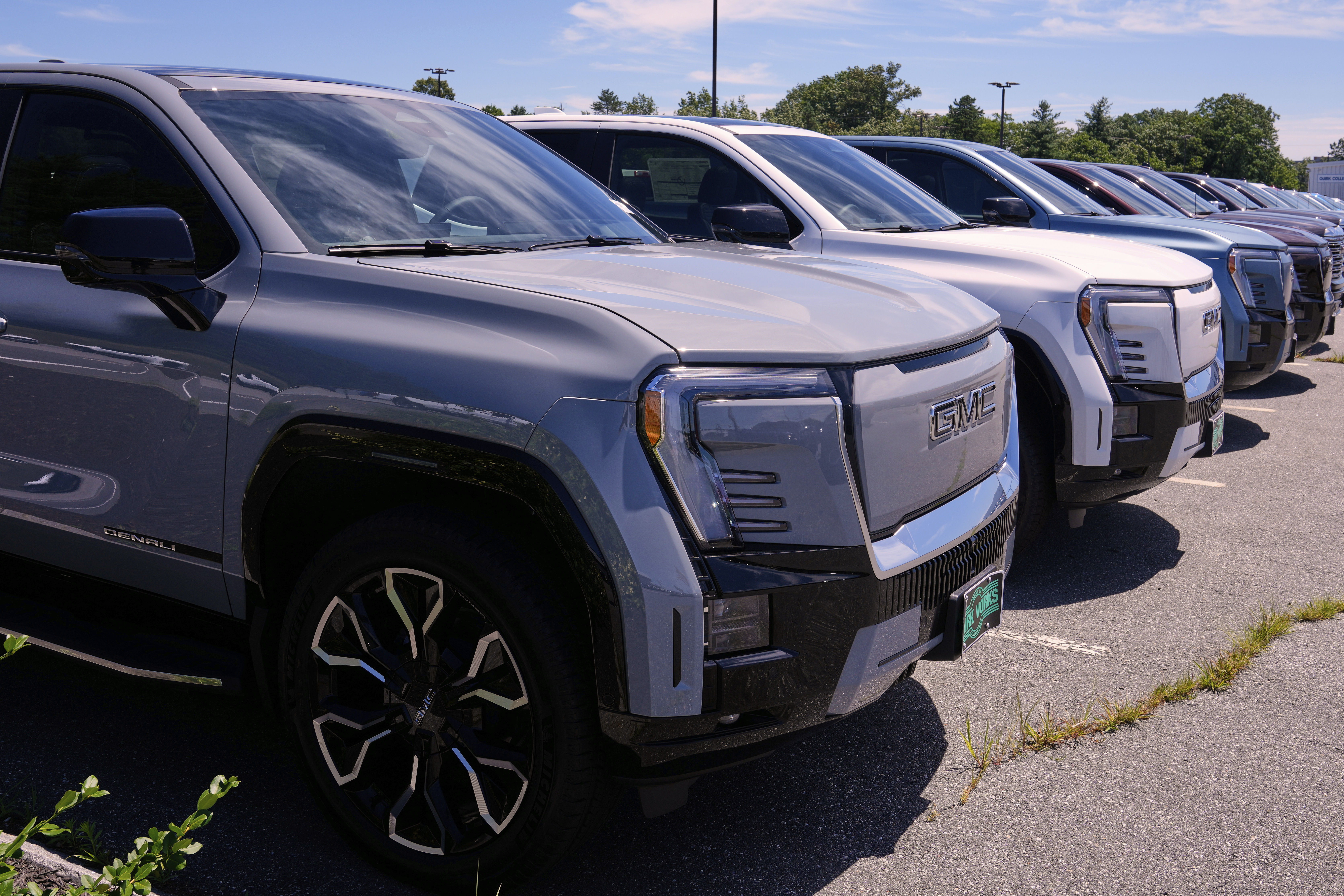 A selection of 2025 GMC Sierra EV Denali pick-up trucks, which are fully electric vehicles, are displayed at a GMC/Hummer truck dealership, Friday, July 18, 2025, in Manchester, N.H. (AP Photo/Charles Krupa)