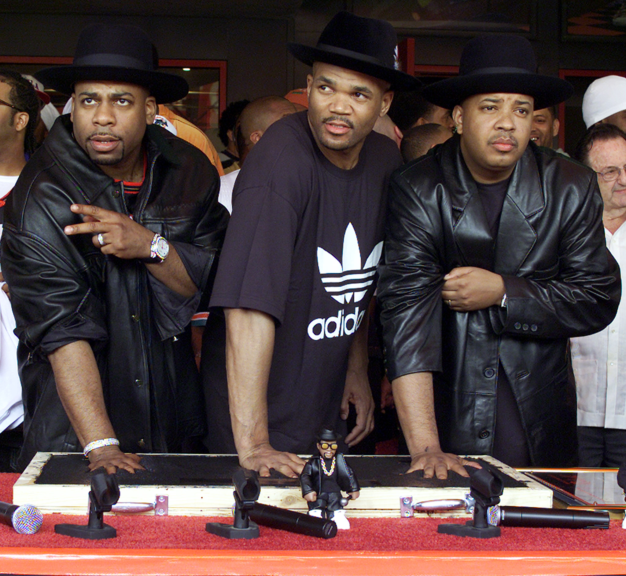Members of the musical group RUN-DMC (L to R) Jason Mizell (Jam Master Jay), Darryl McDaniels (DMC) and Joseph Simmons (DJ Run) make handprints while being inducted into Hollywood's Rockwalk on February 25, 2002 in Los Angeles, California. Hollywood's Rockwalk is a sidewalk gallery dedicated to honouring artists who have made a significant contribution to the evolution of rock 'n roll. REUTERS/Adrees Latif AL/MMR