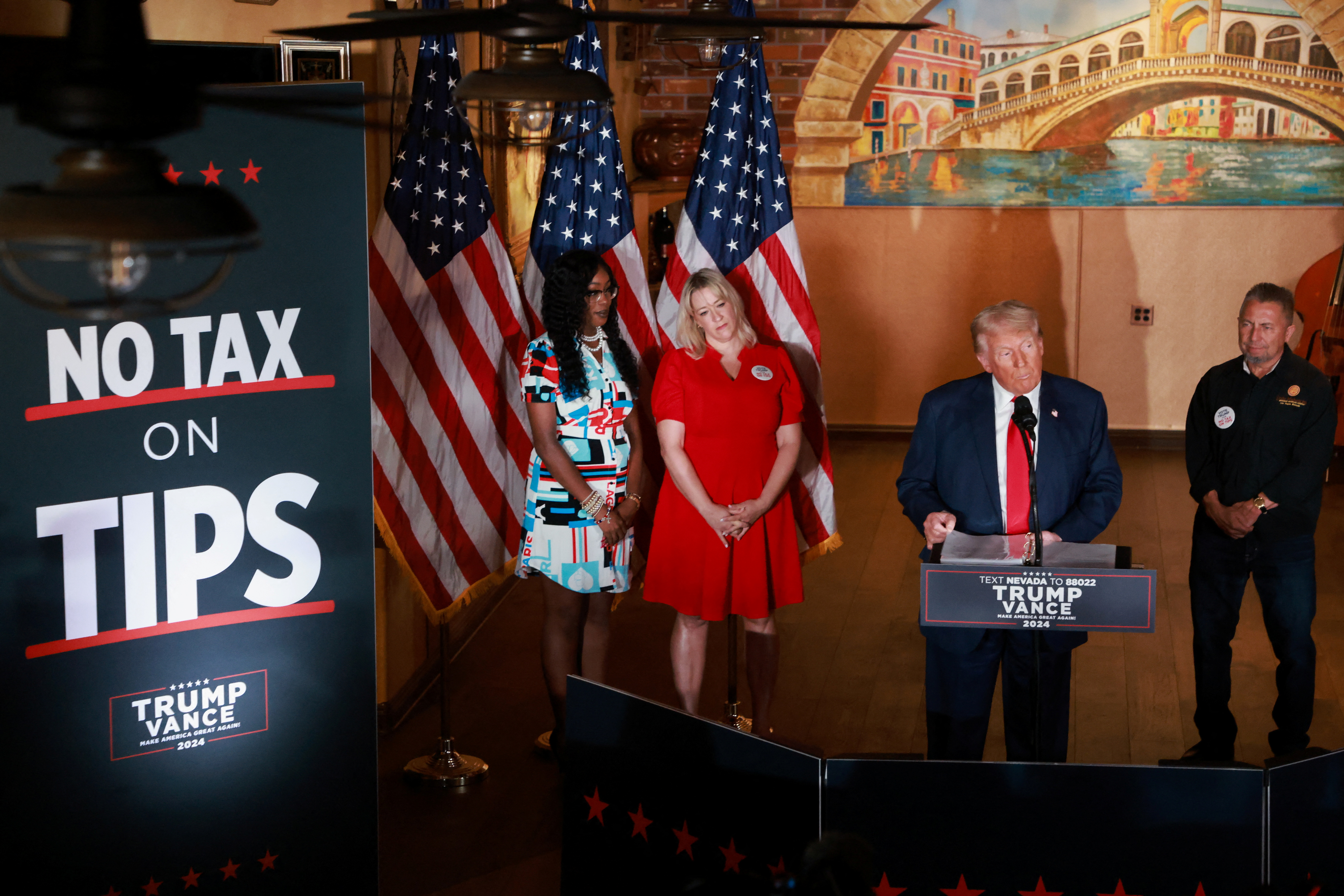 Donald Trump rallies in front of a sign that reads, "No Tax on Tips."