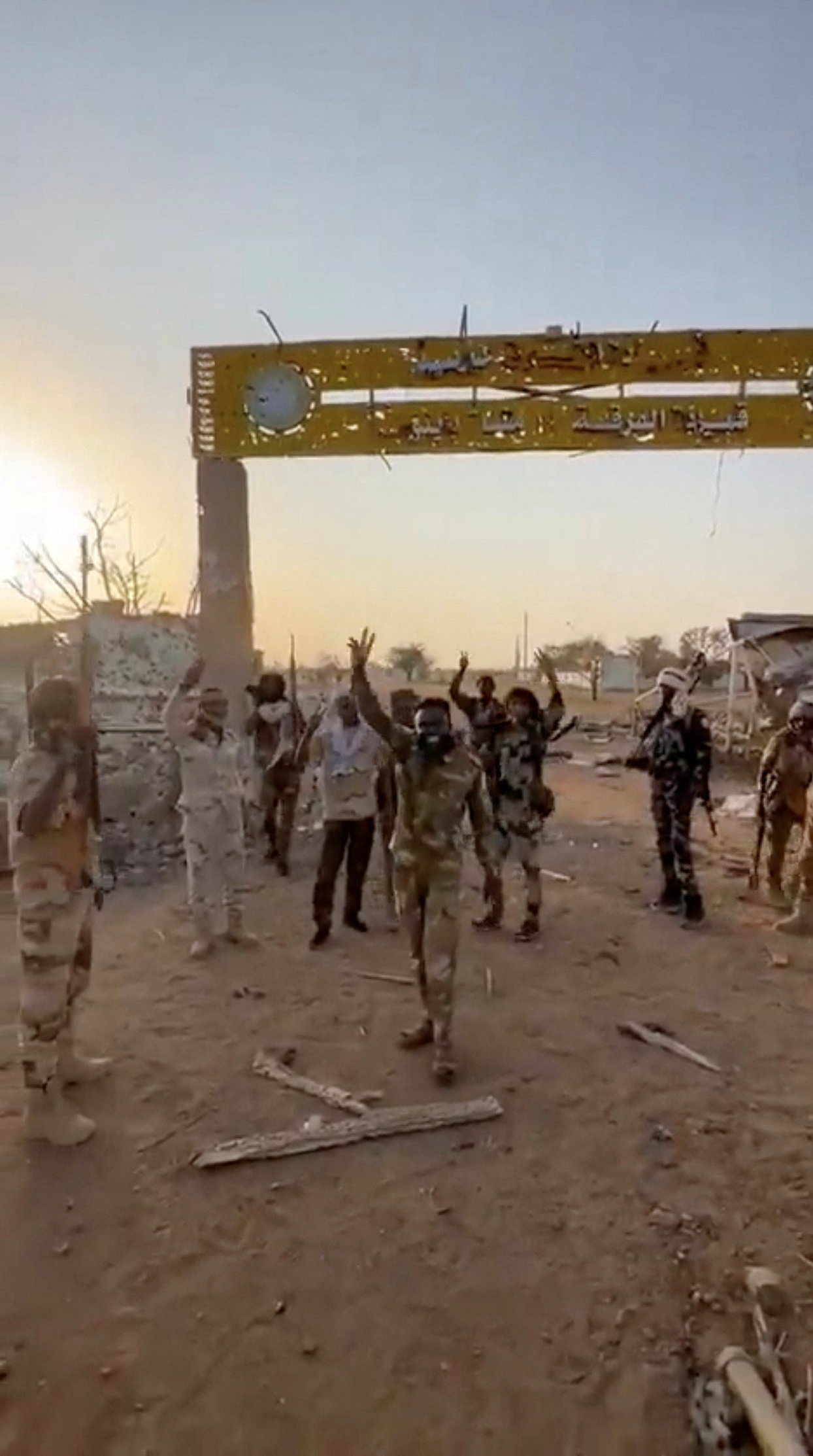 Members of Sudan's paramilitary Rapid Support Forces (RSF) stand in front of a gate of an army base.