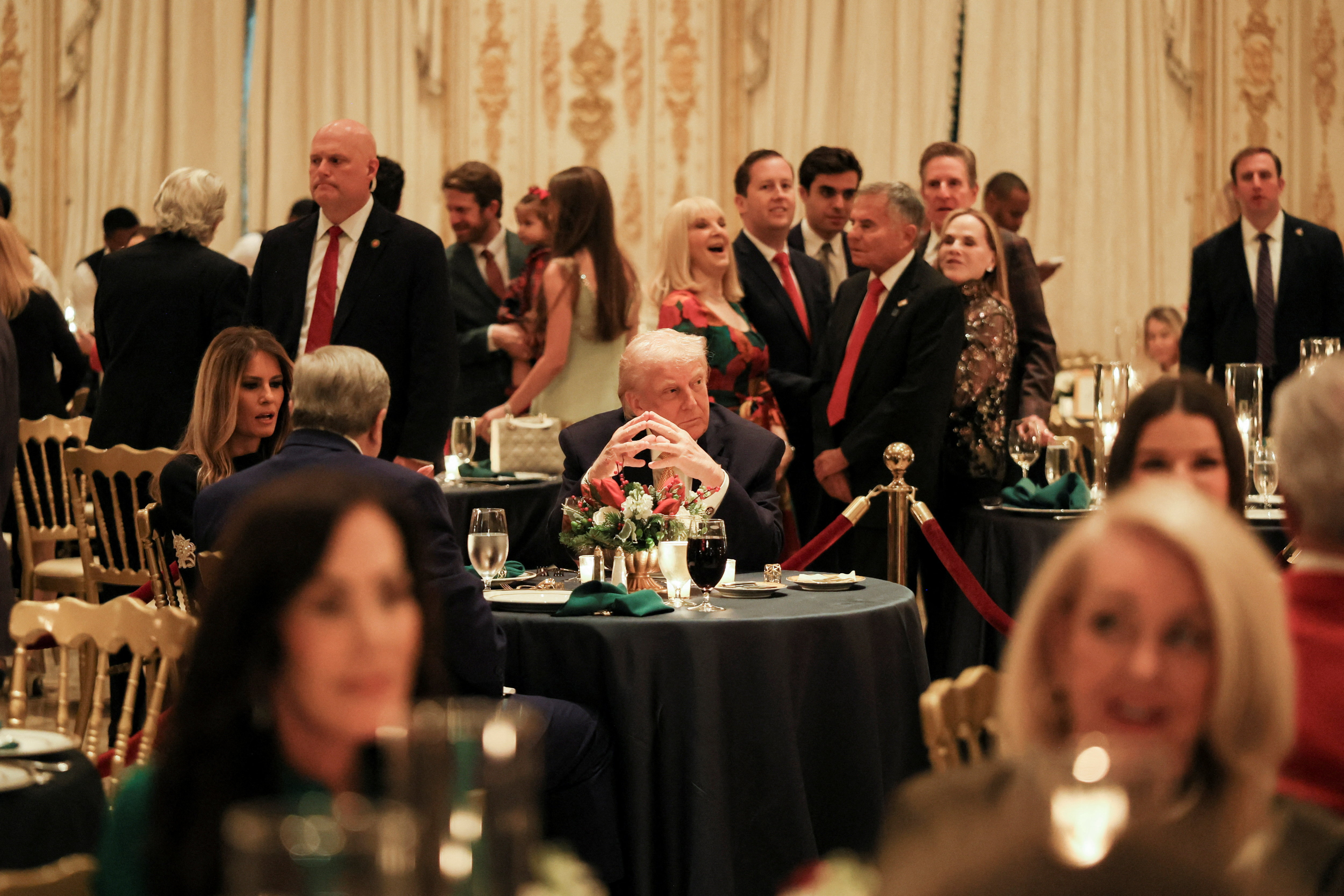 Trump sits at a table at the Mar-a-Lago Christmas Eve Dinner