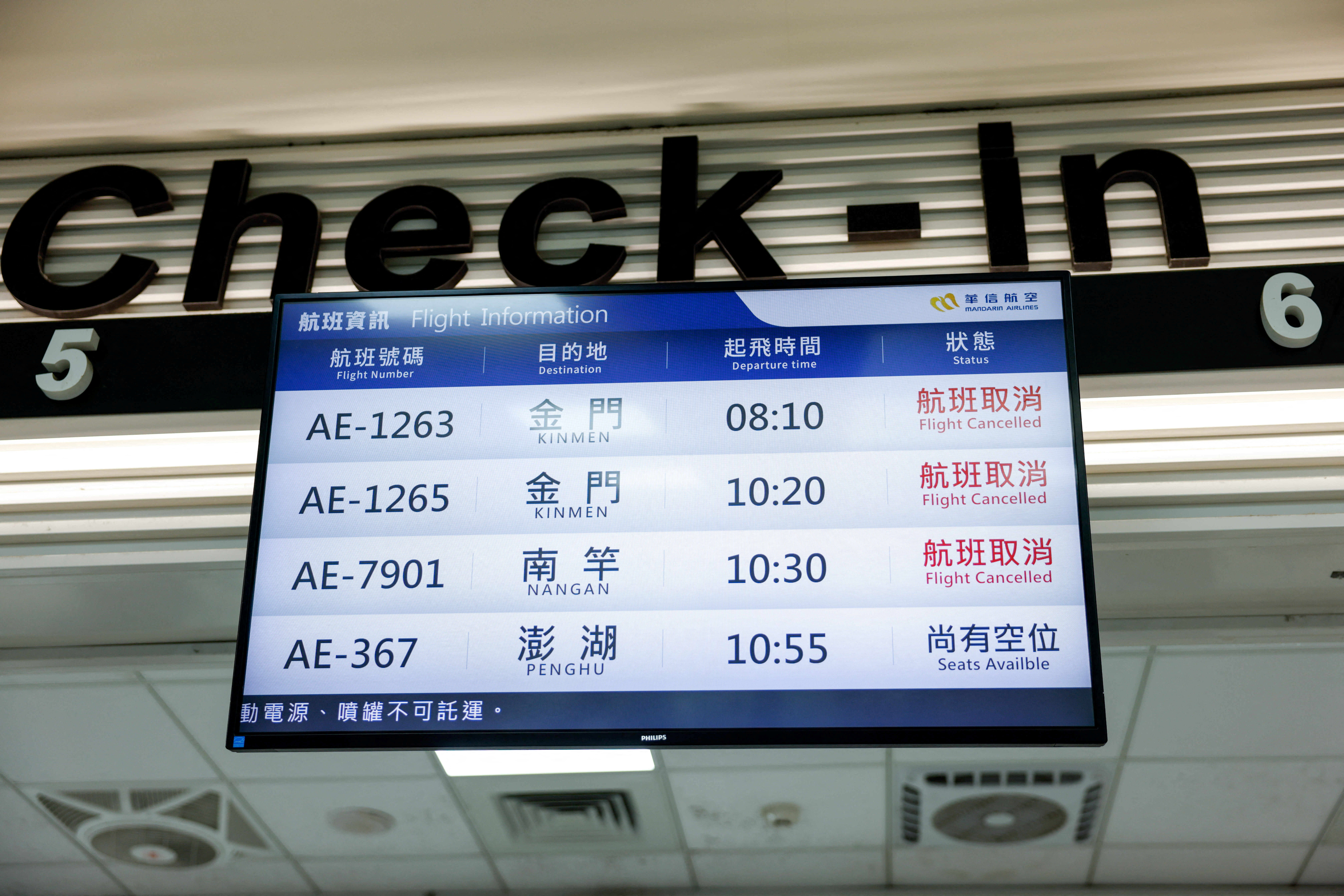 A display screen shows information on cancelled flights at Taipei Songshan Airport, as China conducts "Justice Mission 2025" military drills around Taiwan, in Taipei, Taiwan, December 30, 2025. REUTERS/Ann Wang