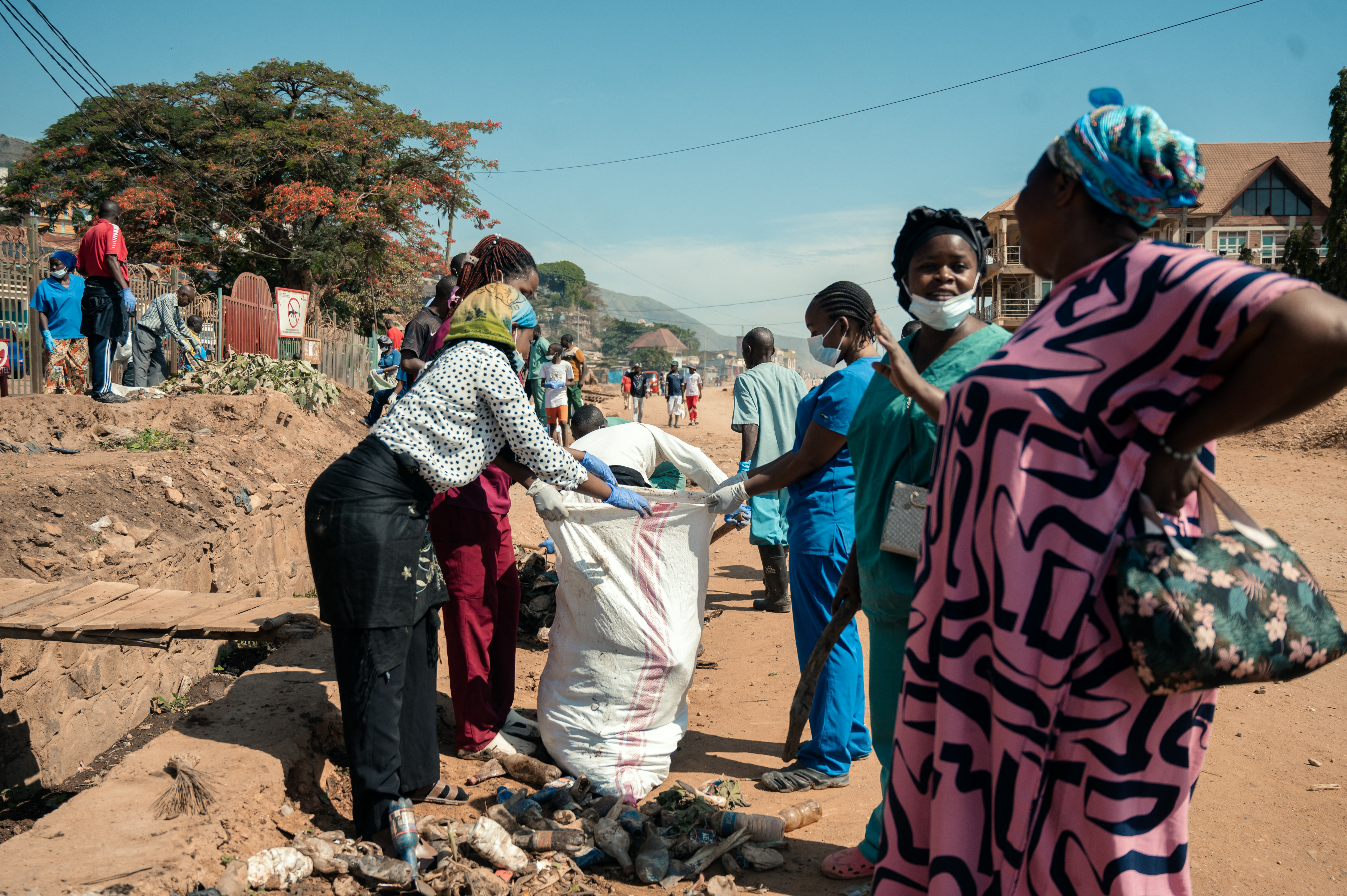 Residents and medical staff carry out a community cleaning exercise outside the Uvira General Referral Hospital following the M23 takeover of the city in Uvira on December 13, 2025. M23 fighters asserted control over Uvira in eastern DR Congo on December 12, 2025, making locals sweep the streets after the city's capture by the Rwanda-backed militia two days ago, residents told AFP. Part of an offensive launched at the beginning of December in South Kivu province along the Burundian border, the armed group's takeover follows its capture of the major cities of Goma and Bukavu in January and February. (Photo by AFP)