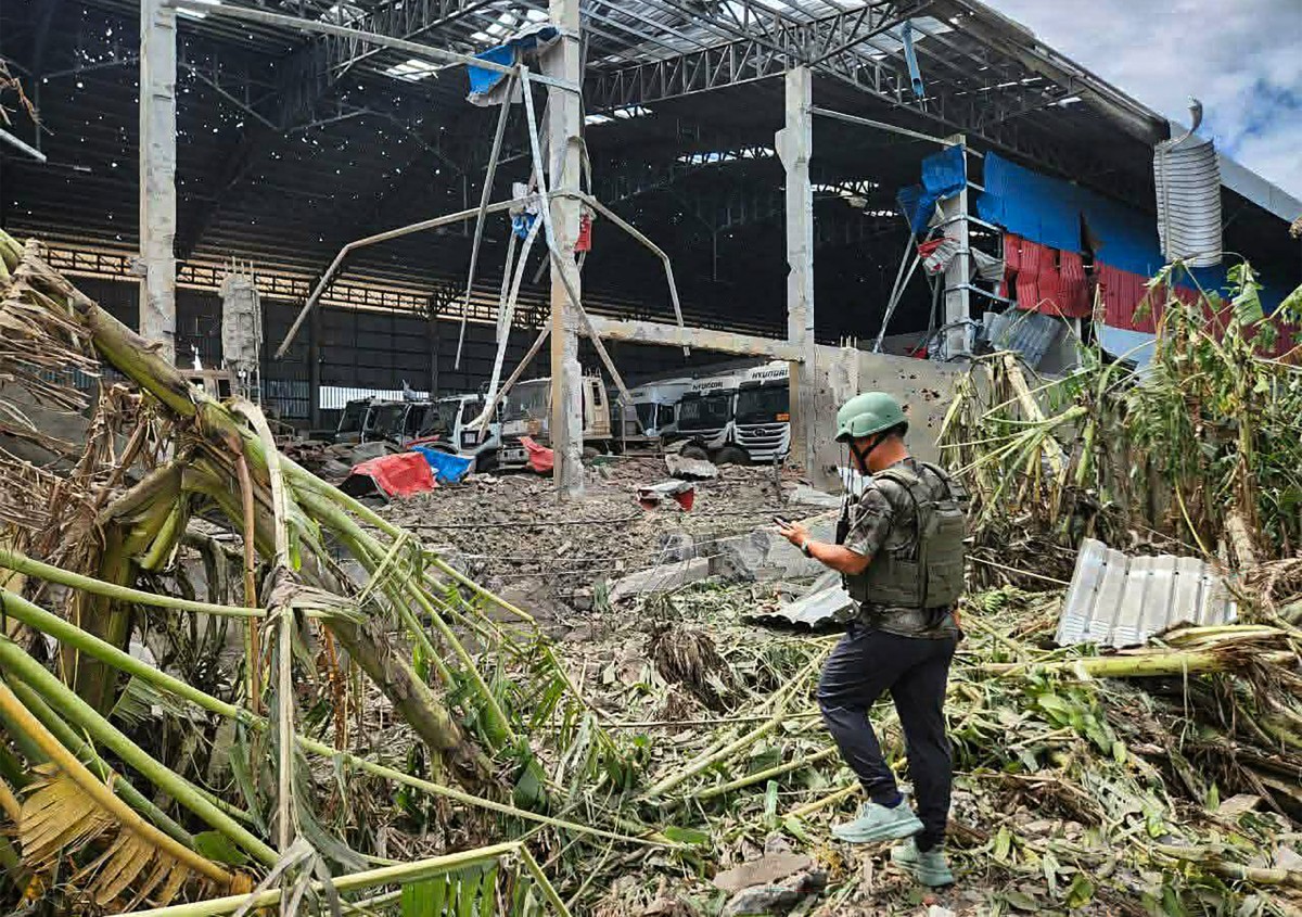 TOPSHOT - This handout photo made available by Agence Kampuchea Press (AKP) on December 18, 2025 shows a man inspecting a garage damaged after Thai air strikes in Poipet town, Banteay Meanchey province, amid clashes along the Cambodia-Thailand border. (Photo by Handout / Agence Kampuchea Press (AKP) / AFP) / RESTRICTED TO EDITORIAL USE - MANDATORY CREDIT "AFP PHOTO / AGENCE KAMPUCHEA PRESS (AKP)" - HANDOUT - NO MARKETING NO ADVERTISING CAMPAIGNS - DISTRIBUTED AS A SERVICE TO CLIENTS