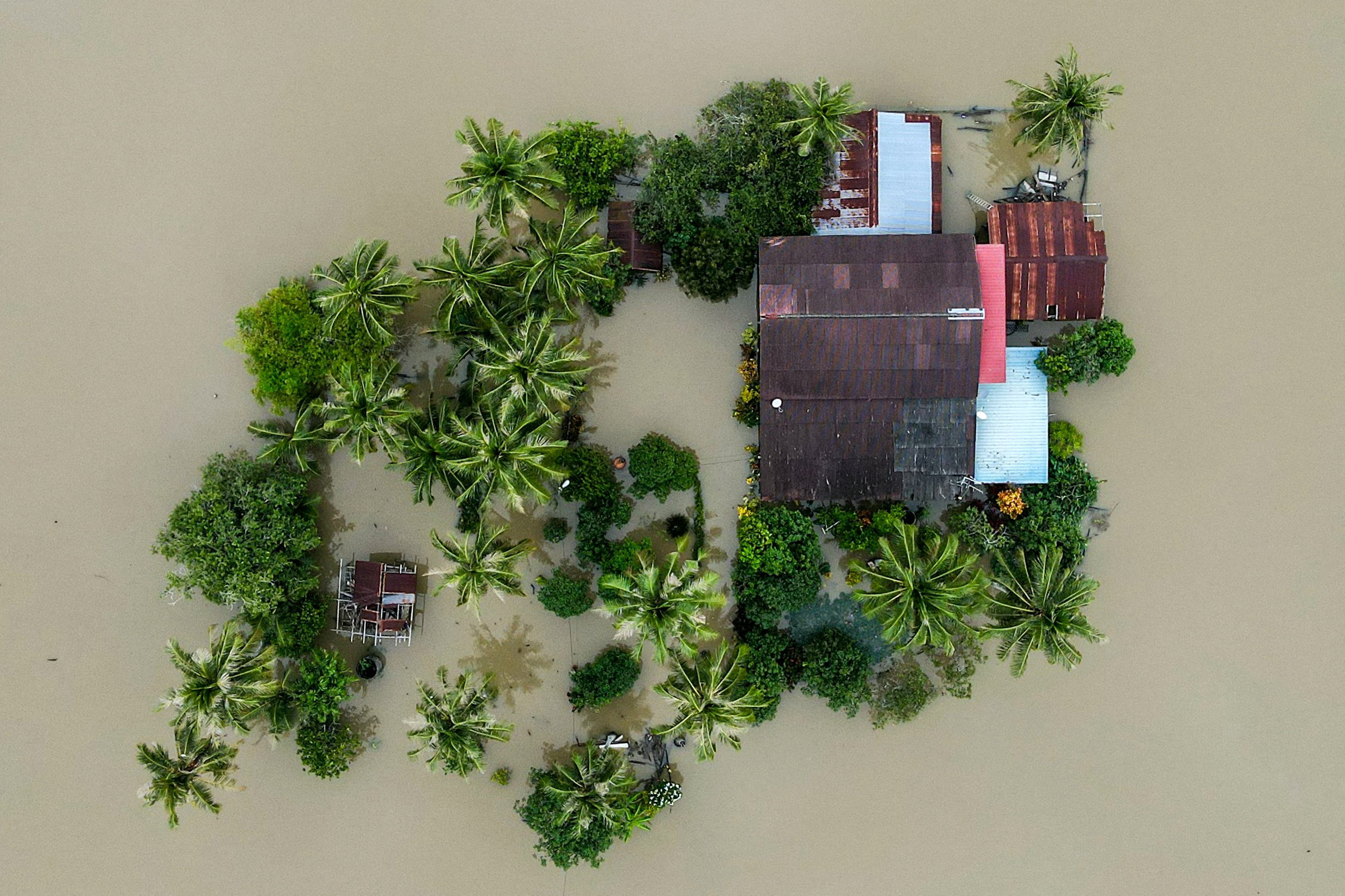 TOPSHOT - An aerial view shows a home surrounded by flood waters in Kangar in northern Malaysia's Perlis state on November 28, 2025, as severe flooding affected thousands of people in the region following days of heavy rain.