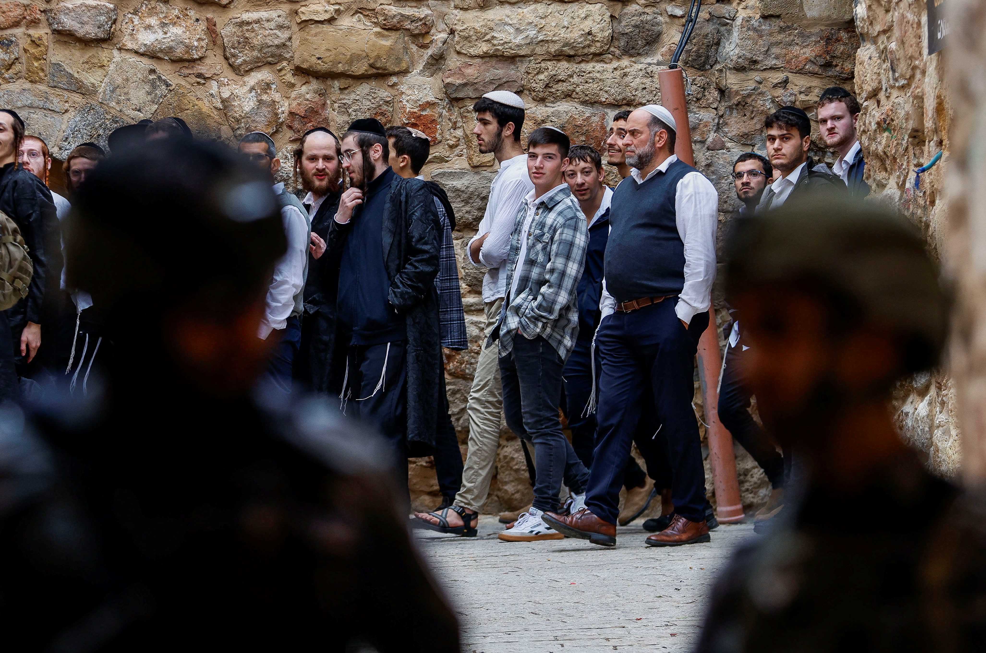 Israelis walk past troops standing guard during a weekly settlers' tour in Hebron, in the Israeli-occupied West Bank, December 13, 2025. REUTERS/Mussa Qawasma