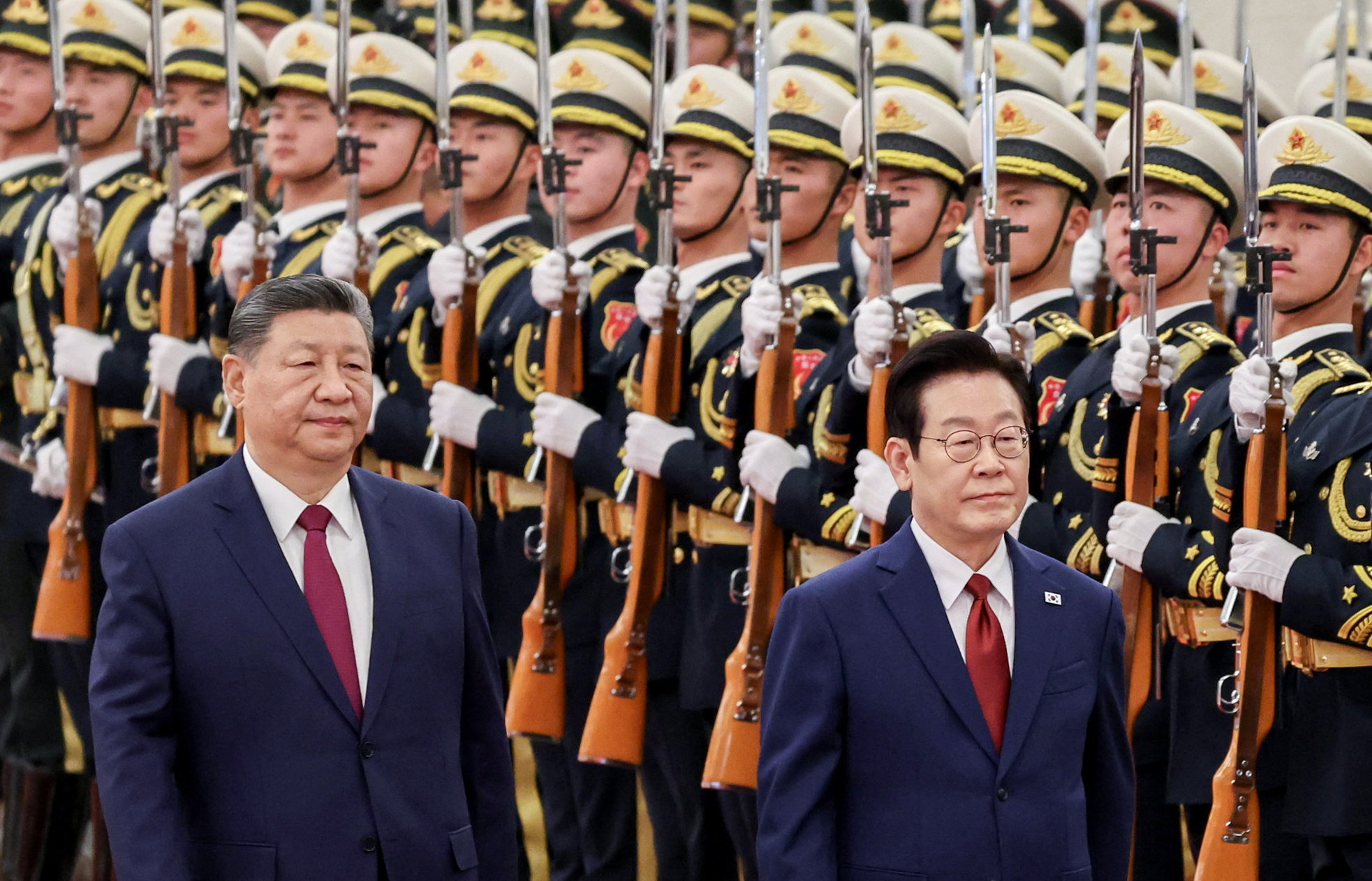 Chinese President Xi Jinping and South Korean President Lee Jae Myung inspect honor guards during a welcome ceremony at the Great Hall of the People in Beijing, China