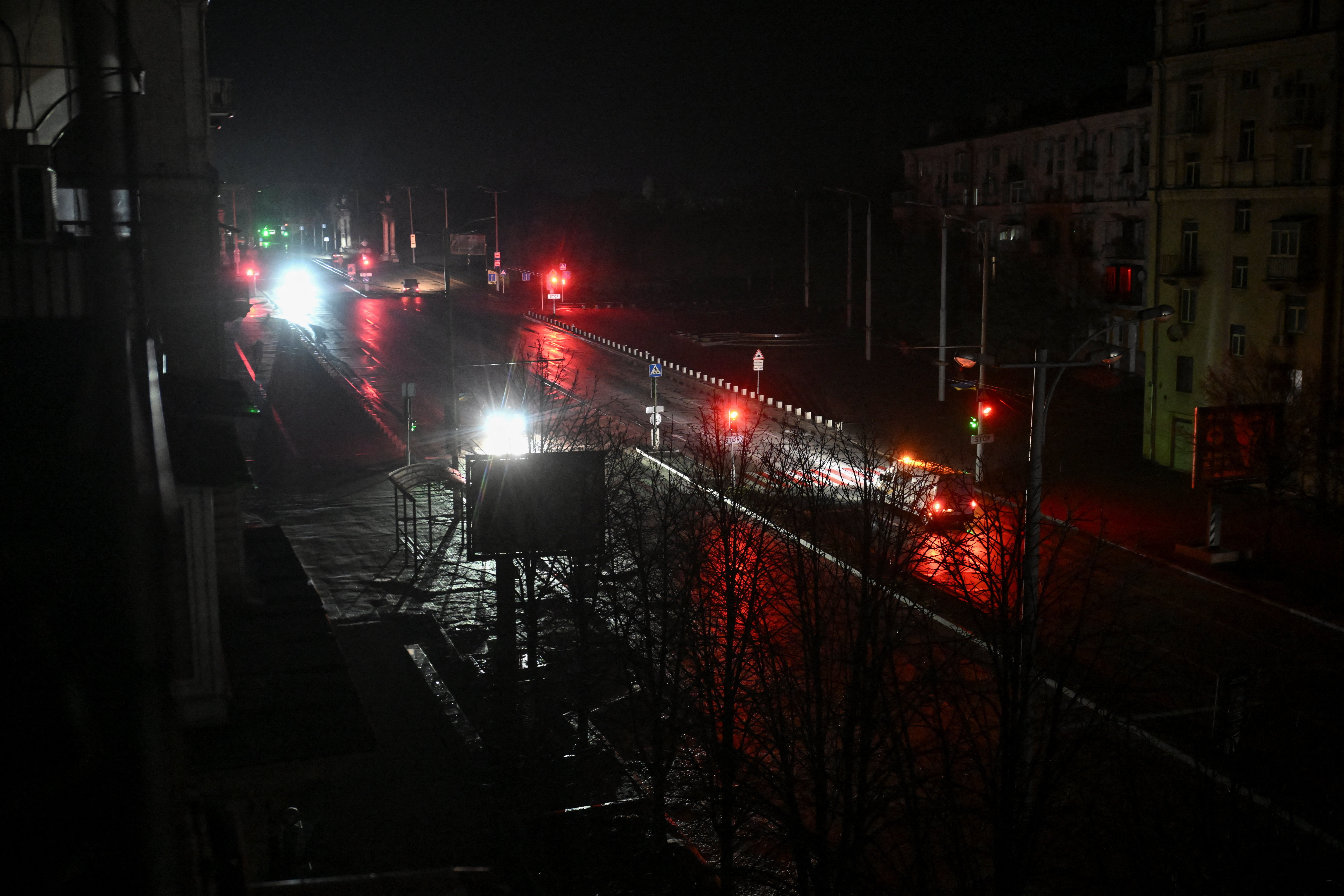 Cars move along a dark street during a power blackout.