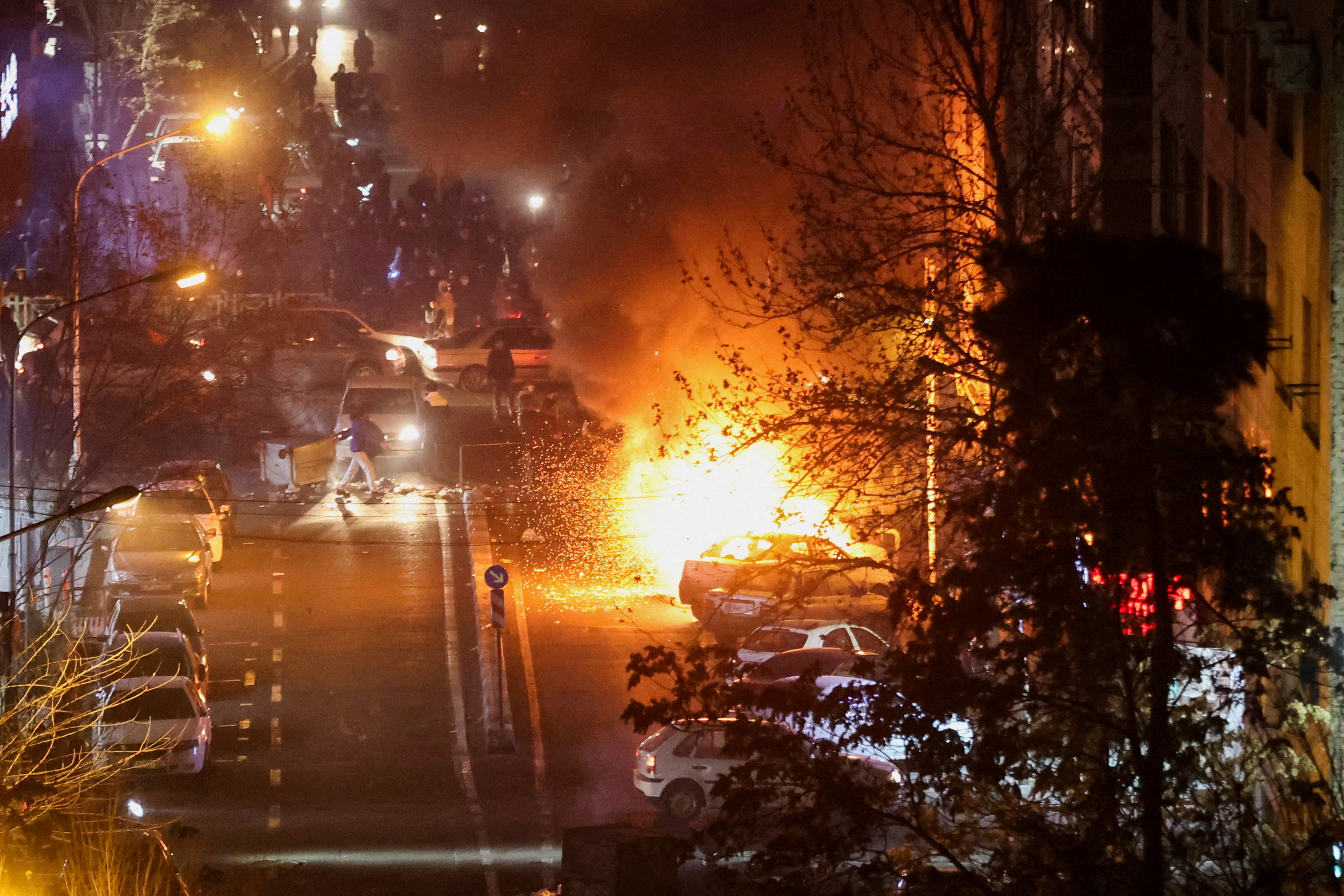 Cars burn in a street during a protest over the collapse of the currency's value, in Tehran, Iran