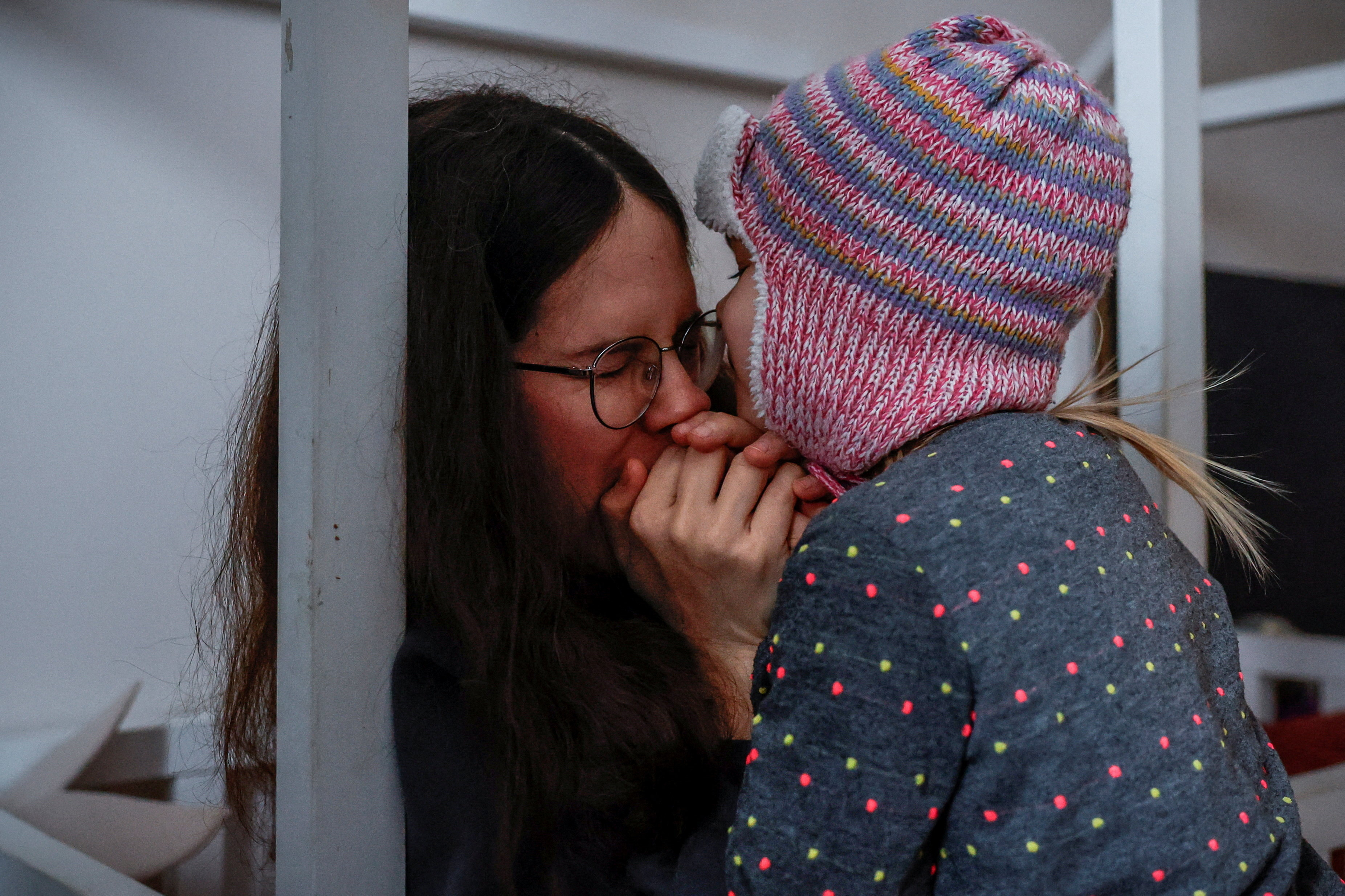 Yuliia Chumak, 32, who is eight months pregnant, warms her daughter’s, Kvitoslava, 3, hands with her breath, as they get ready to leave for the kindergarten in their apartment during power cuts after critical civil infrastructure was hit by recent Russian missile and drone strikes, amid Russia’s attack on Ukraine, in Kyiv, Ukraine, January 14, 2026. REUTERS/Alina Smutko TPX IMAGES OF THE DAY