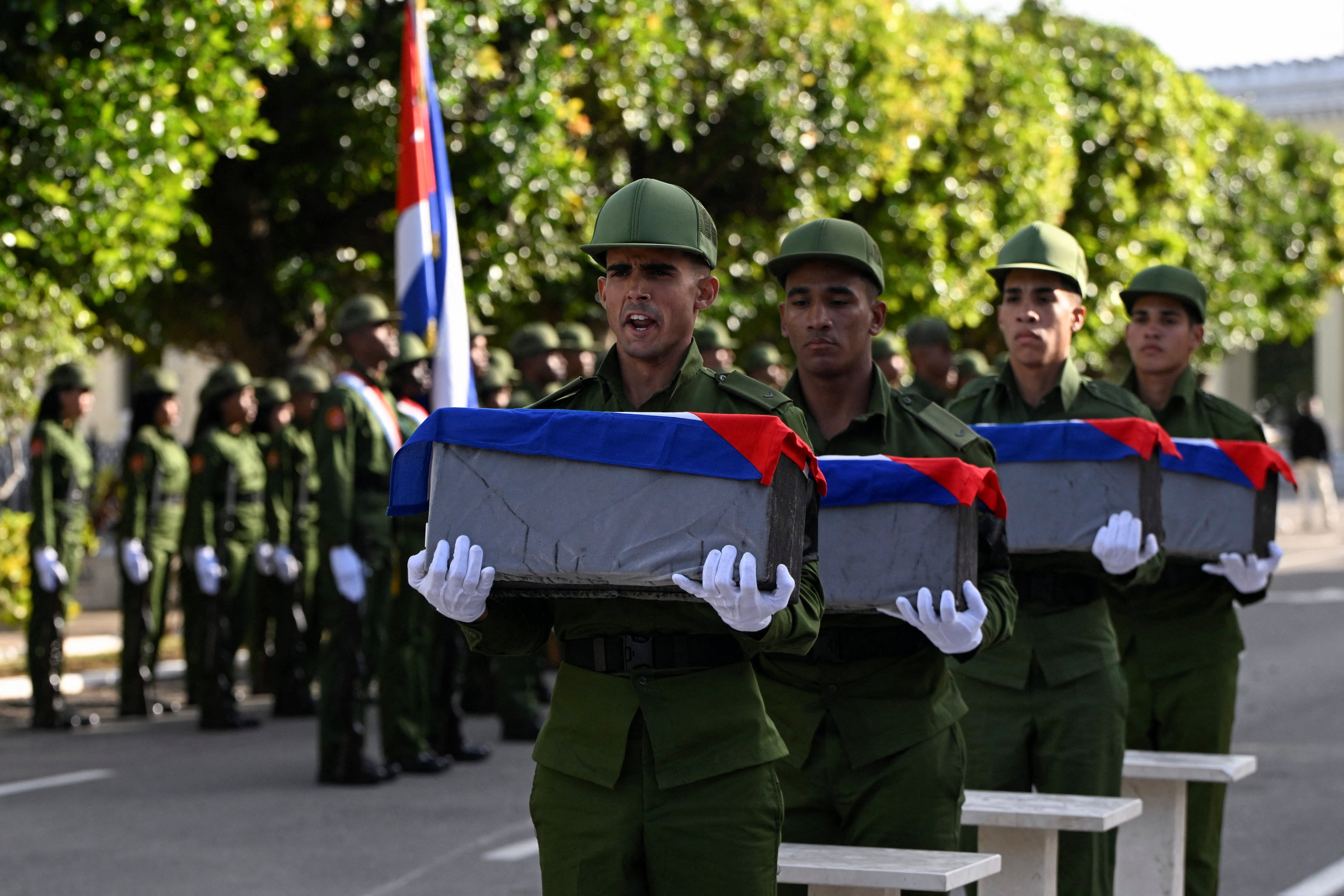 Members of Cuba's military honour guard carry Cuban‑flag‑draped urns containing the remains of soldiers killed in the U.S. strike and the capture of Venezuelan President Nicolas Maduro and his wife, Cilia Flores, in Caracas on January 3, during their funeral at Colon Cemetery in Havana, Cuba, January 16, 2026. REUTERS/Norlys Perez
