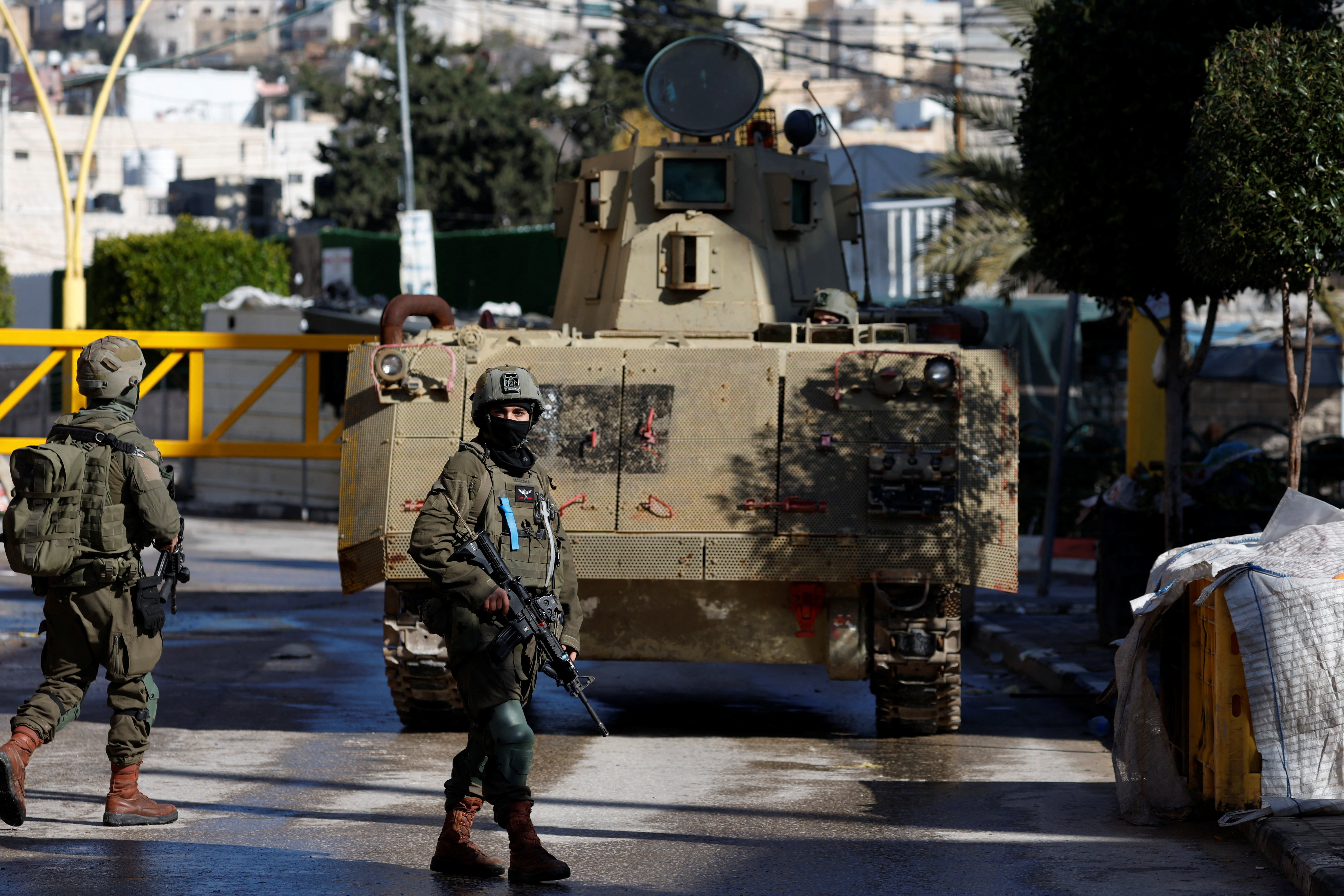 Israeli soldiers take position during a raid in Hebron