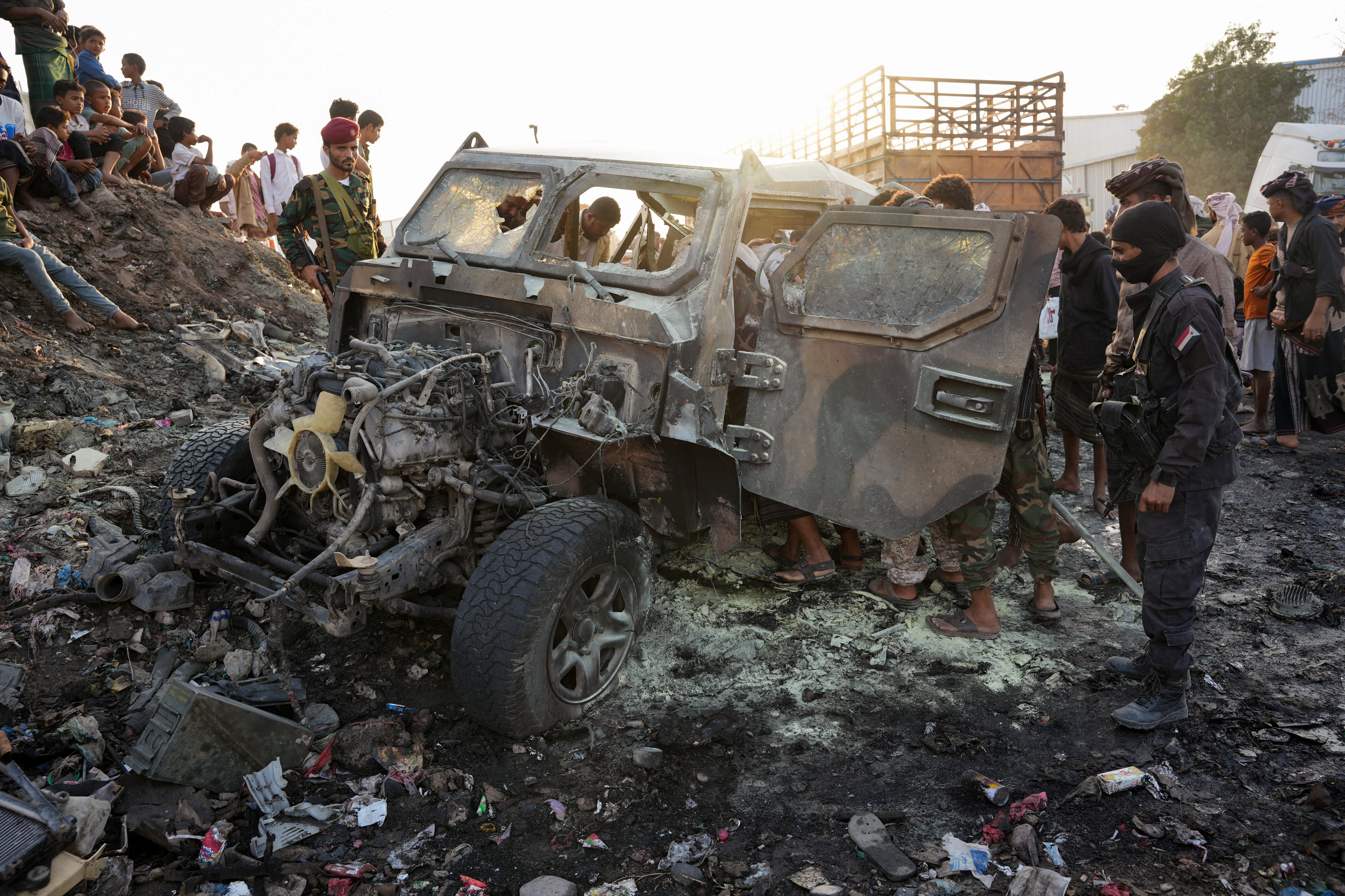 Members of security forces inspect the site of a deadly car bomb attack near the southern port city of Aden, Yemen