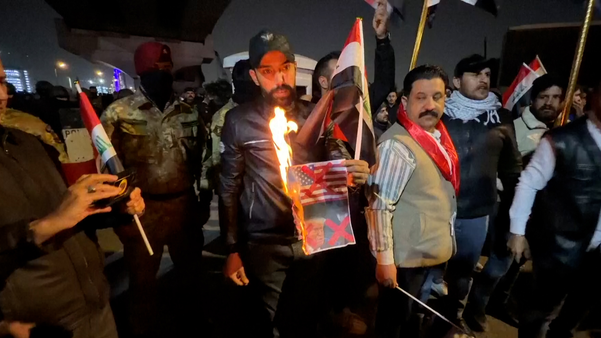 A protester in Baghdad burns a photo of Donald Trump, rejecting the US president’s demand that former Prime Minister Nouri al-Maliki not return to the premiership. [Screenshot via AP]
