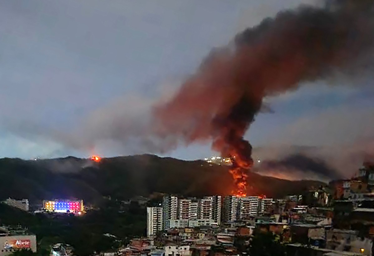 Fire at Fuerte Tiuna, Venezuela's largest military complex, is seen from a distance after a series of explosions in Caracas on January 3, 2026. The United States military was behind a series of strikes against the Venezuelan capital Caracas on Saturday, US media reported. The White House and Pentagon have not commented on the explosions and reports of aircraft over the city. US media outlets CBS News and Fox News reported unnamed Trump administration officials confirming that US forces were involved.