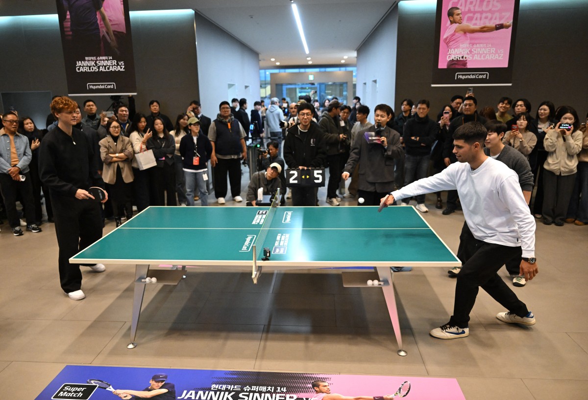 Italy's Jannik Sinner (L) plays table tennis with Spain's Carlos Alcaraz (R) during a welcome event at Hyundai Card headquarters in Seoul on January 9, 2026, ahead of their tennis exhibition match. (Photo by Jung Yeon-je / AFP)