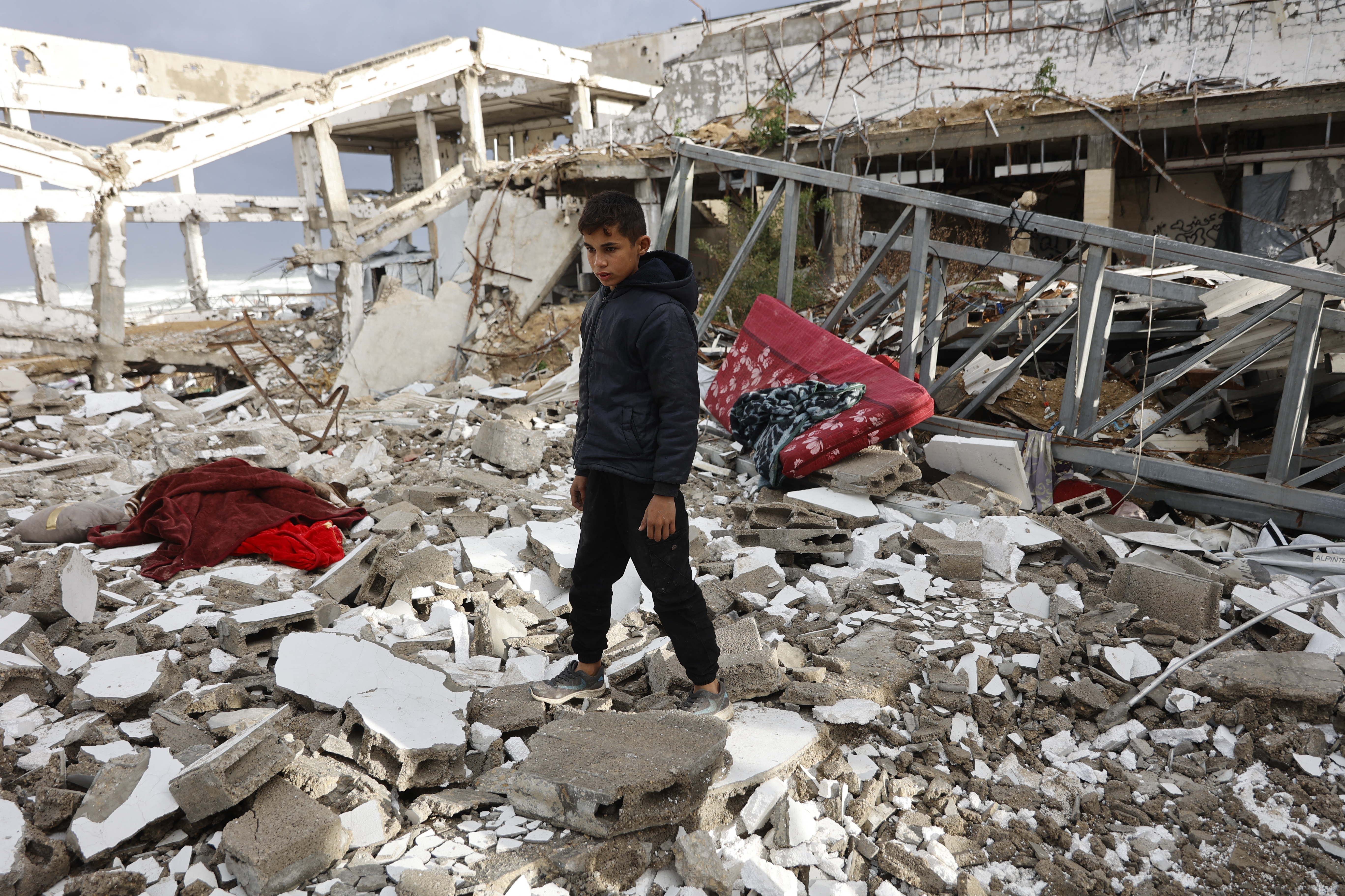 A Palestinian boy stands amid the rubble inside a war-damaged building, parts of which collapsed on a windy winter day in Gaza City on January 13, 2026. [Photo by Omar AL-QATTAA / AFP]