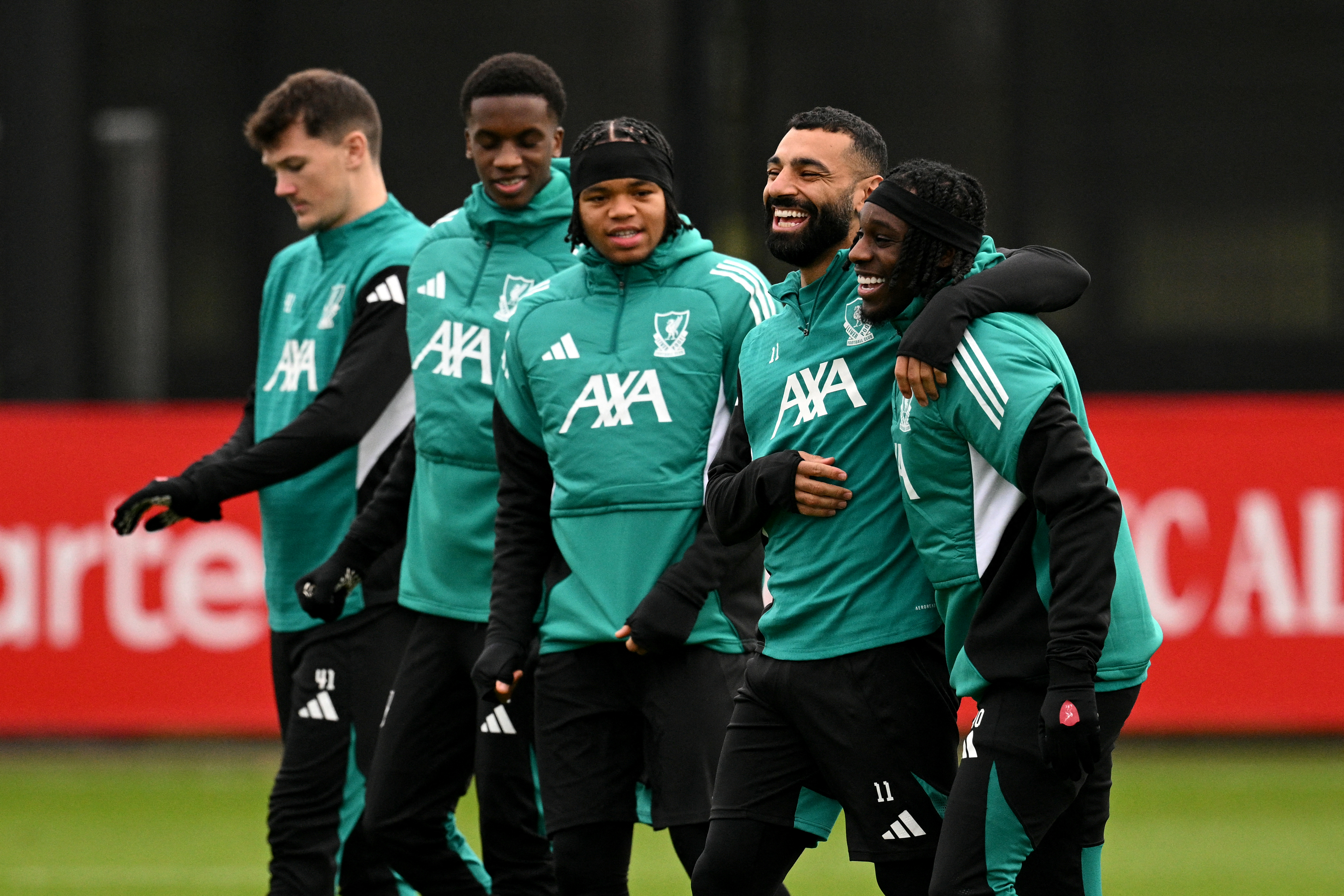 Salah, second from right, laughs with Liverpool teammate Jeremie Frimpong during a training session in Kirkby outside Liverpool in northwest England on January 20, 2026