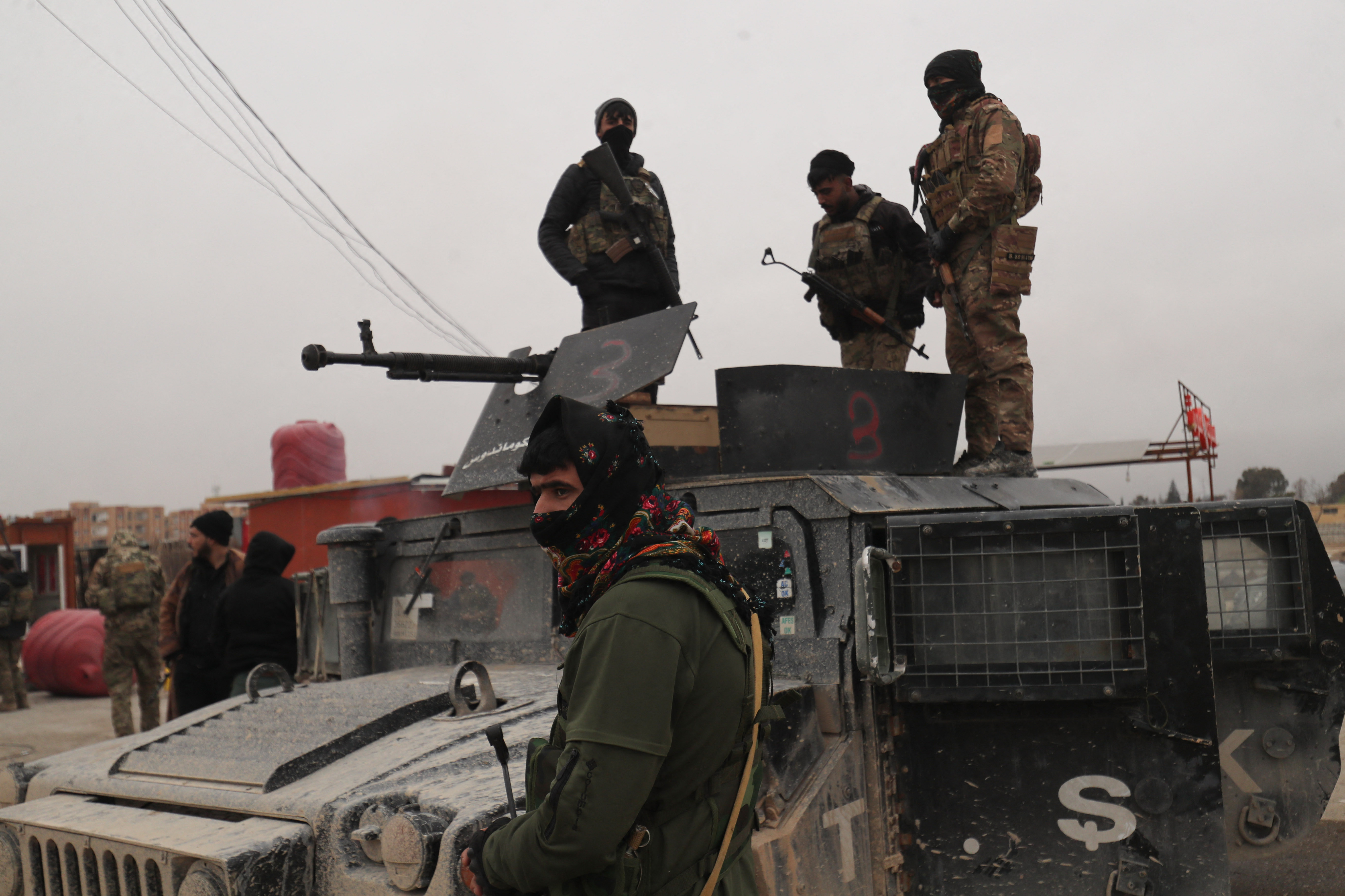 This photo taken on January 22, 2026 shows Syrian Democratic Forces fighters that took position to secure the frontline and the areas near the prison where IS detainees are held in Hasakeh. The US military said Januart 22 its forces had transported 150 IS fighters from jail in northeast Syria's Hasakeh province "to a secure location in Iraq". Up to 7,000 detainees could be transferred under the deal, although no timeframe was specified. The Kurdish-led Syrian Democratic Forces (SDF) seized territory in north and east Syria during around four years battling the jihadists with the support of a US-led anti-IS coalition, before territorially defeating the extremists in 2019. (Photo by Delil SOULEIMAN / AFP)