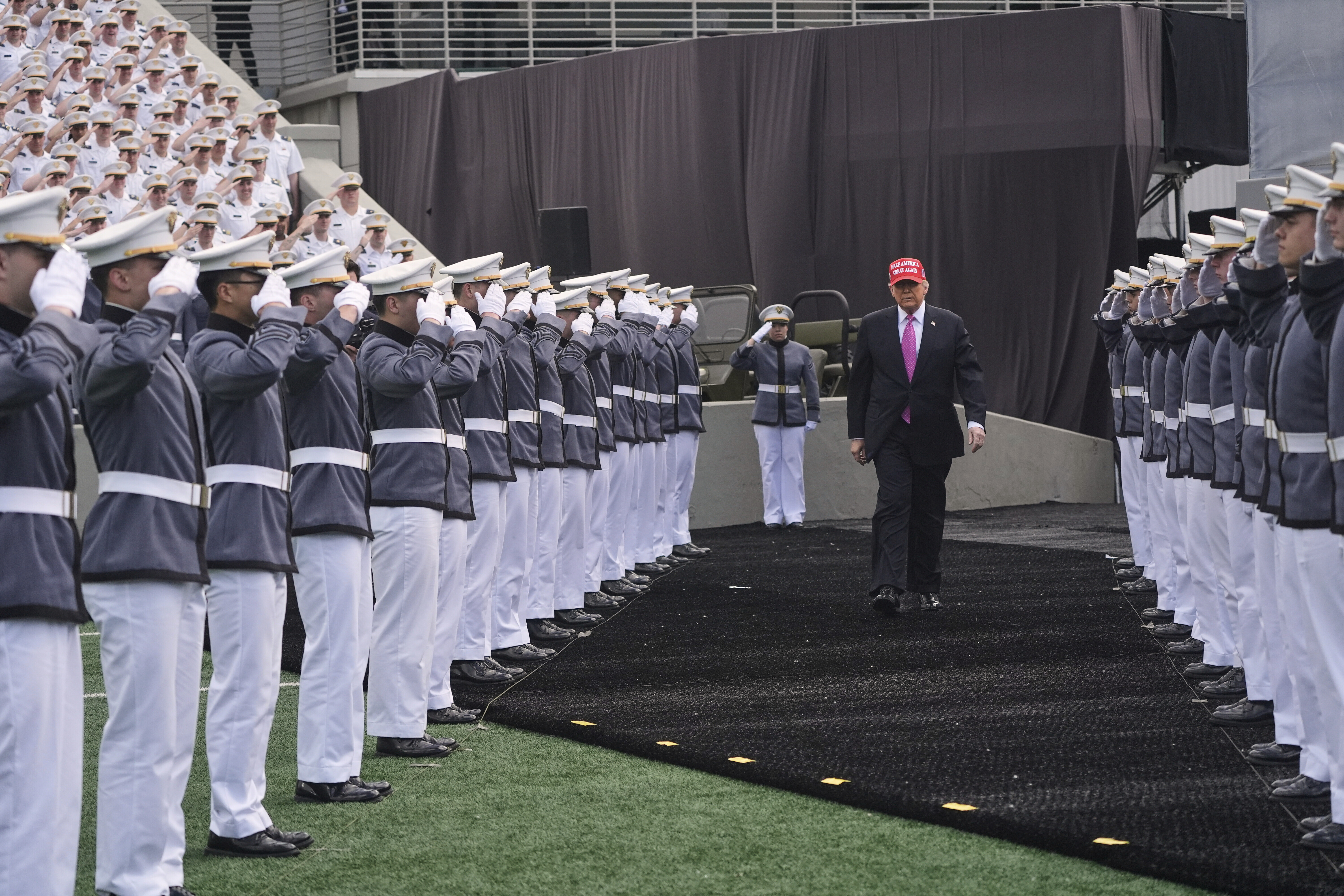 Trump walks down a row of young military members