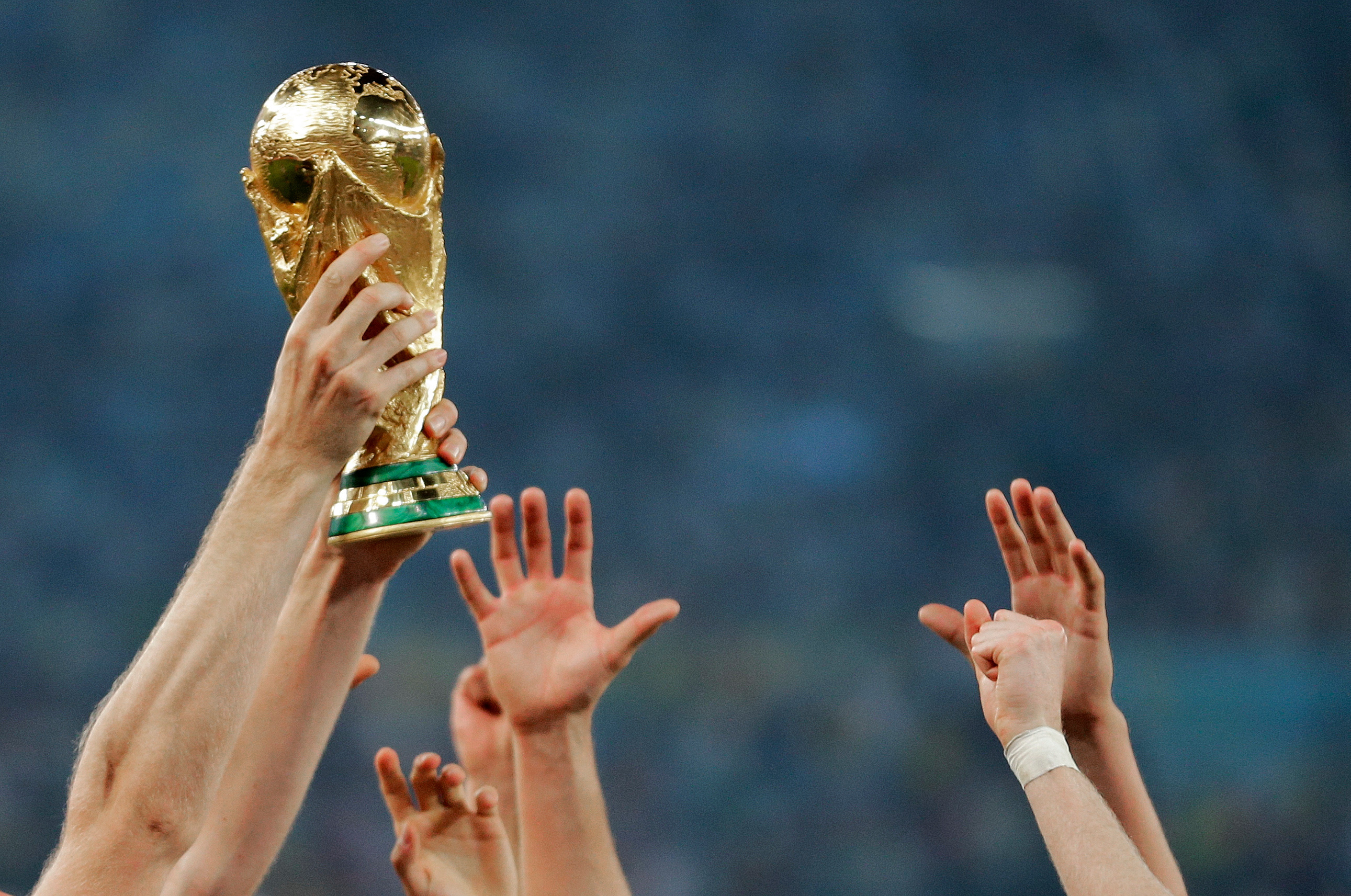 German players reach out to touch the trophy after the World Cup final soccer match between Germany and Argentina, in Rio de Janeiro, Brasil, July 13, 2014