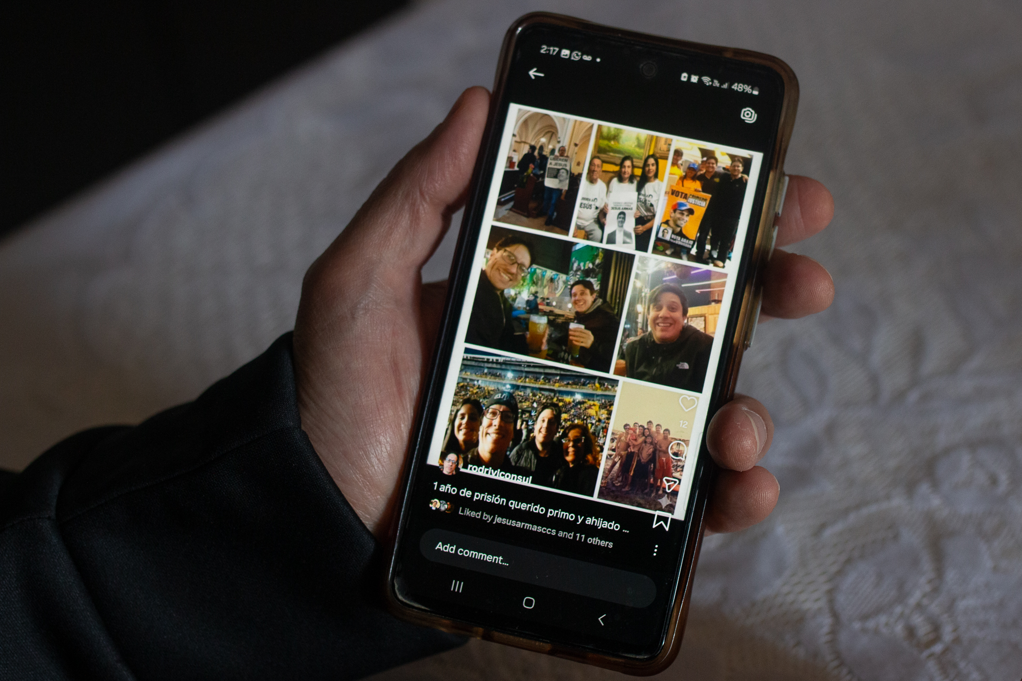 Jesus Rodriguez shows a phone with photos of his imprisoned relative Jesus Armas