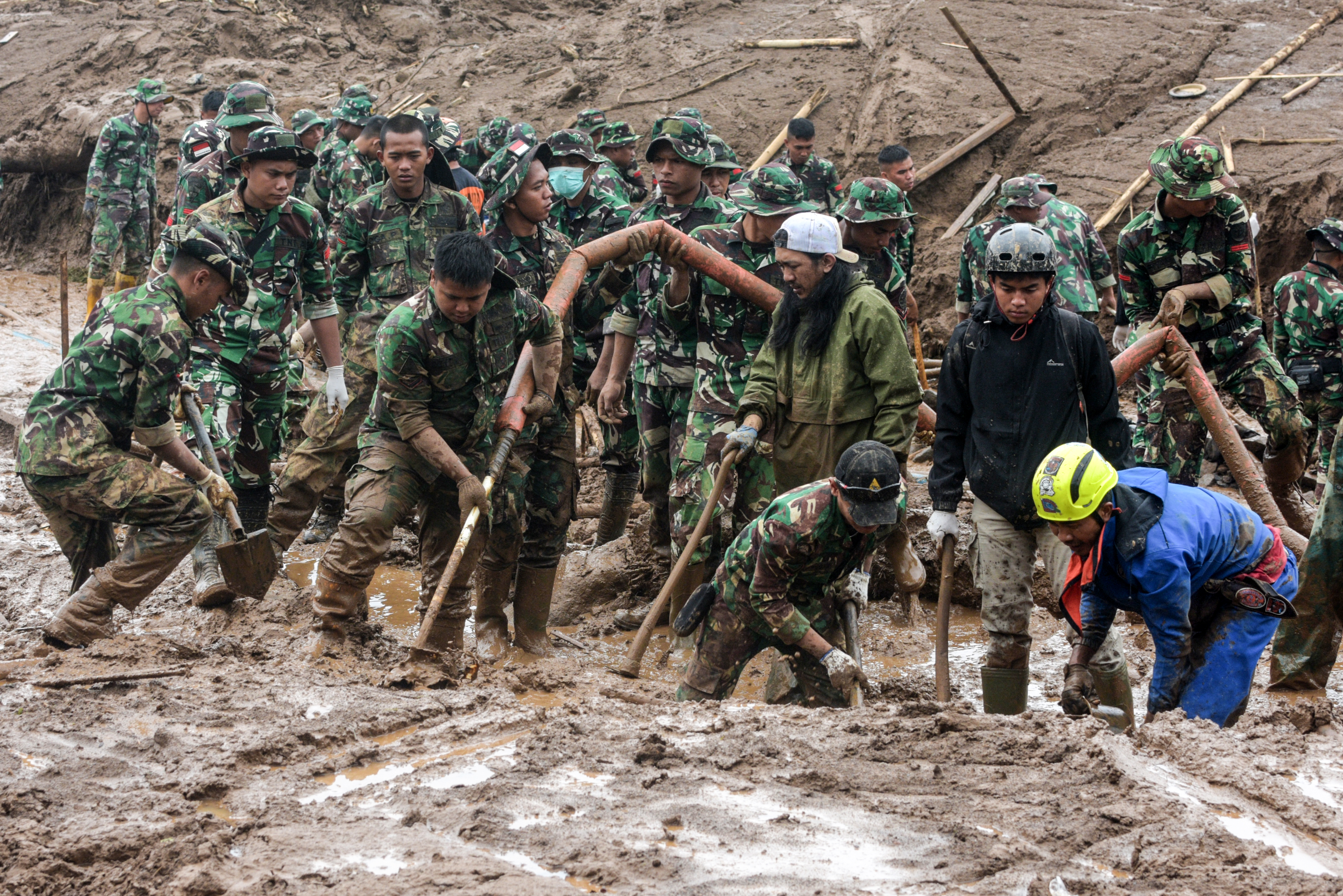 Rescuers search for victims buried by a landslide.