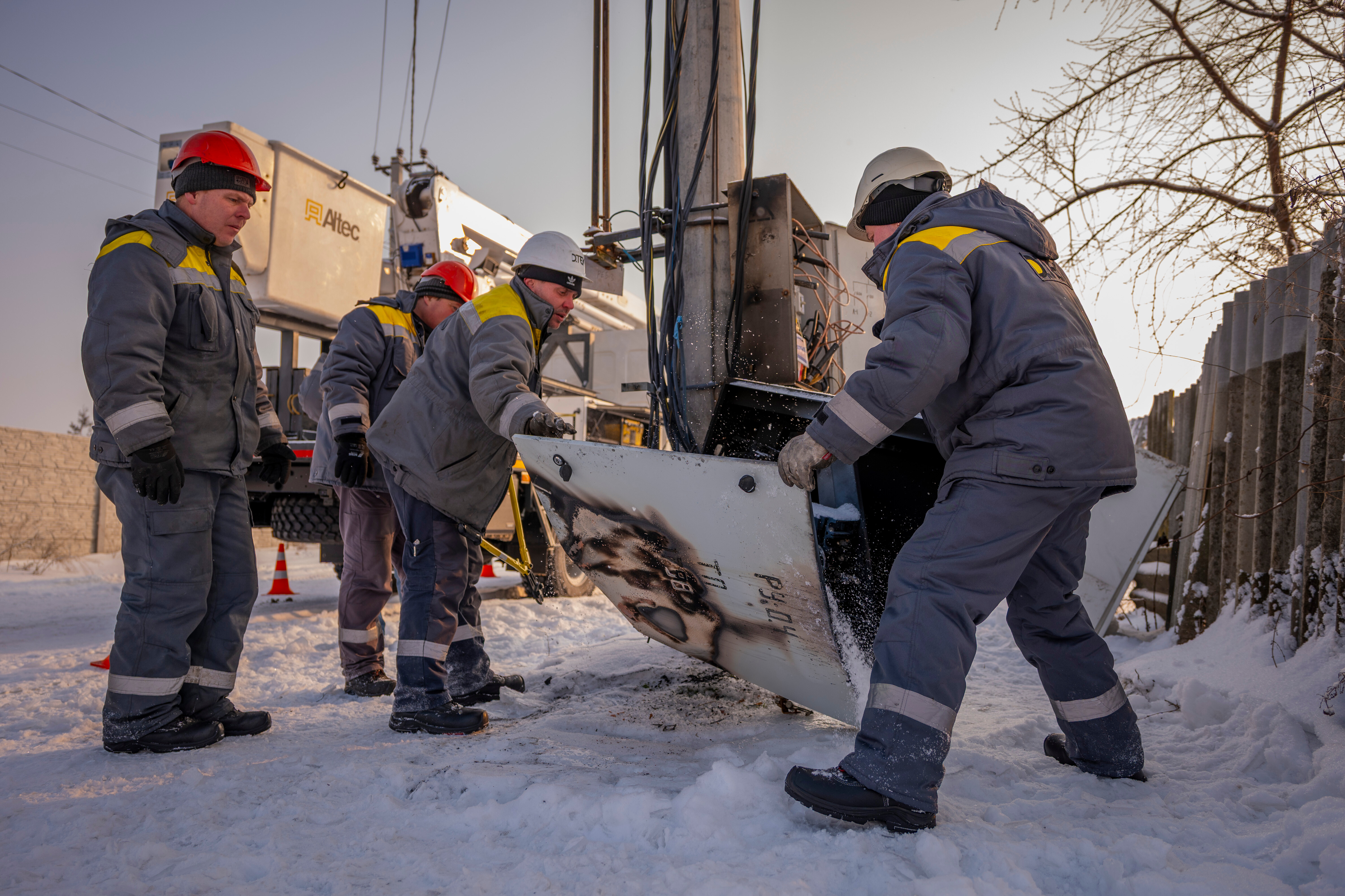 Electricians carry out emergency repairs on a power pole after a transformer burned out due to a voltage surge caused by regular Russian air attacks on the country's energy infrastructure in Kyiv region, Ukraine, Wednesday, Jan. 14, 2026. (AP Photo/Dan Bashakov)