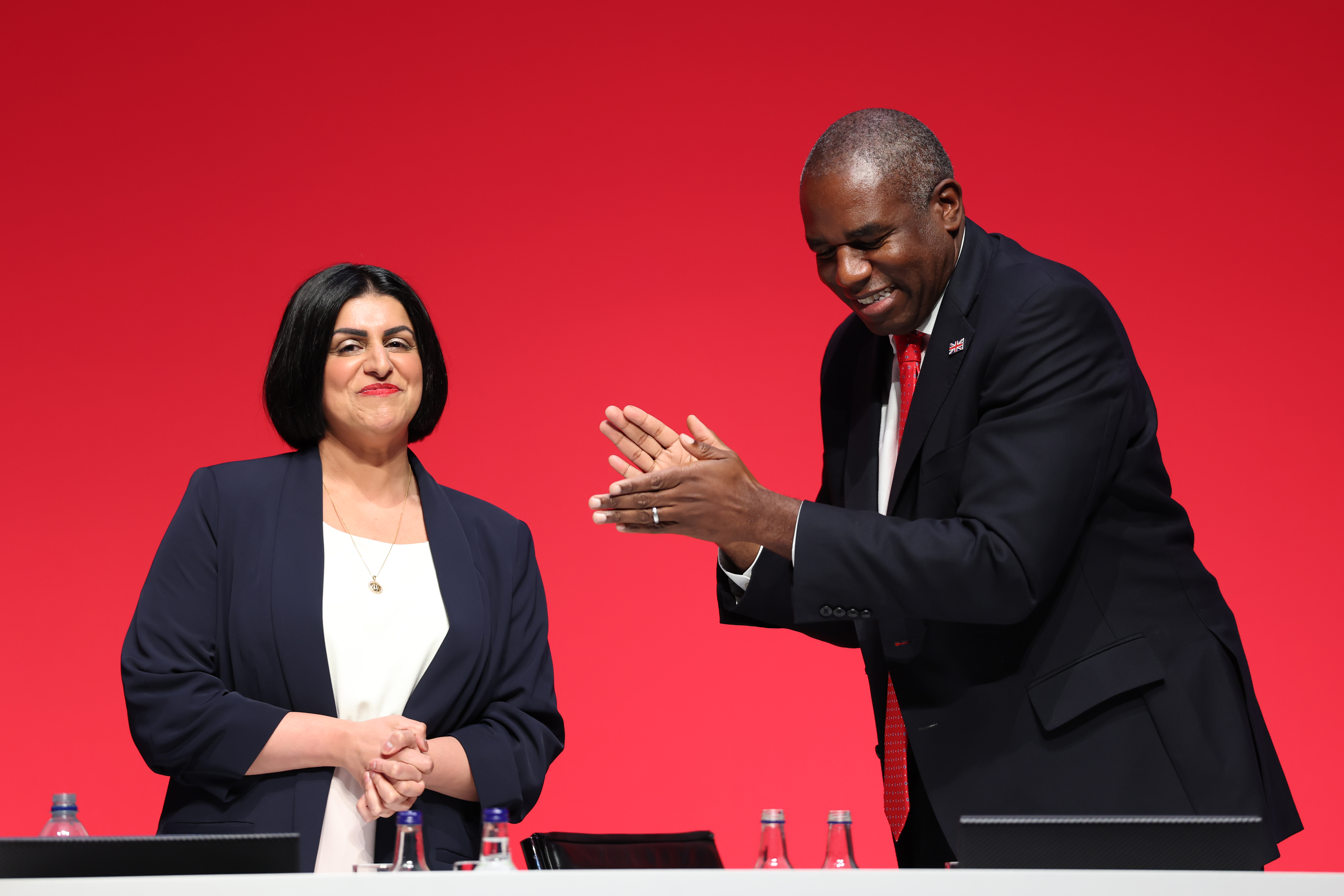 LIVERPOOL, ENGLAND - SEPTEMBER 29: Home Secretary Shabana Mahmood MP (L) reacts next to Justice Secretary and deputy Prime Minister David Lammy after speaking on stage during day two of the Labour Party conference at ACC Liverpool on September 29, 2025 in Liverpool, England. The Labour Conference is being held against a vastly different backdrop to last year when the party had swept to power in a landslide general election victory. A year on and polling shows three quarters of Britons (74-77%) say they have little to no trust in the party on the cost of living, immigration, taxation, managing the economy, representing people like them, or keeping its promises. (Photo by Jeff J Mitchell/Getty Images)