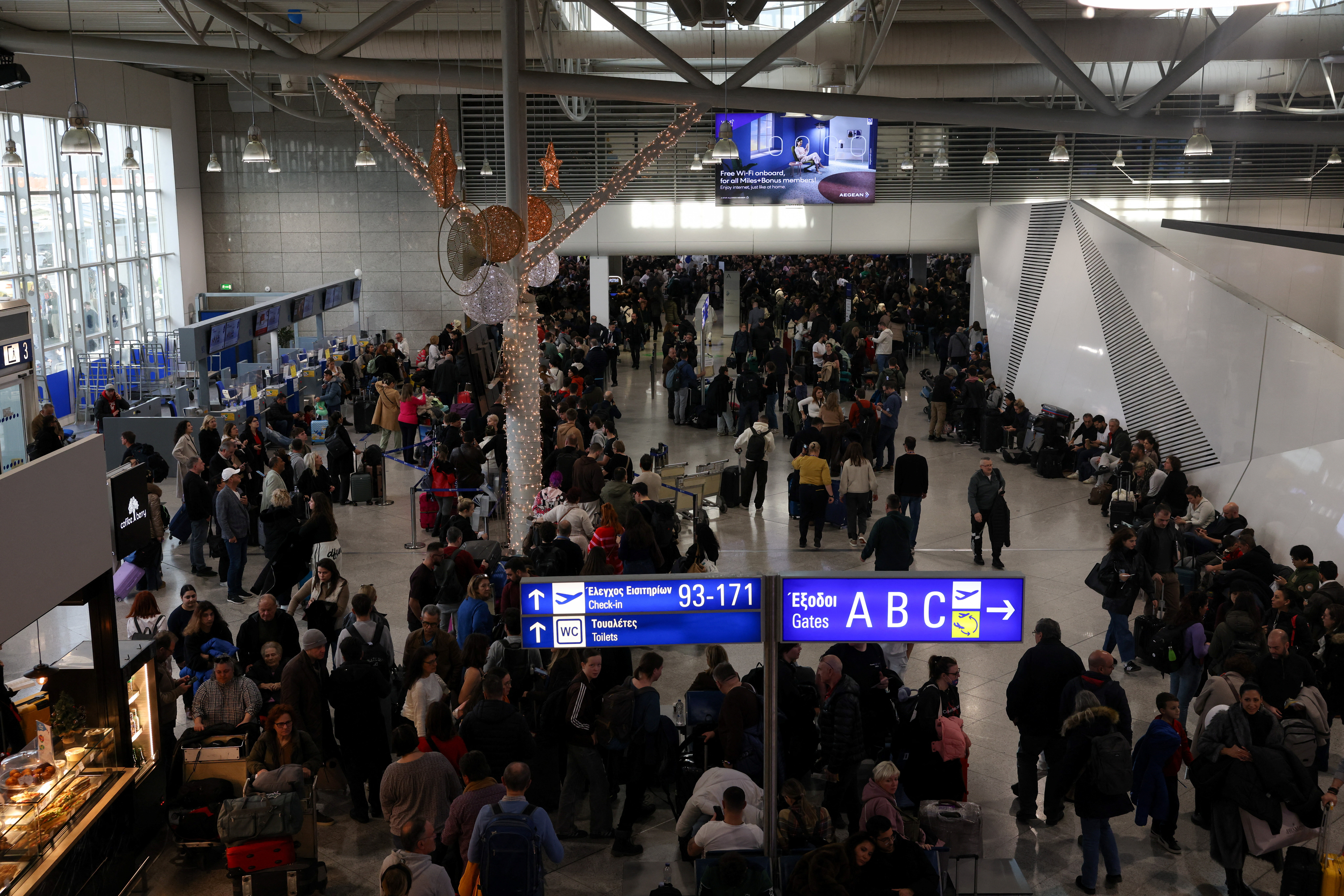 People gather as airports across Greece have suspended arrivals and departures on Sunday, after unspecified issues affecting radio frequencies, at the Eleftherios Venizelos International Airport, in Athens, Greece, January 4, 2026. REUTERS/Louiza Vradi