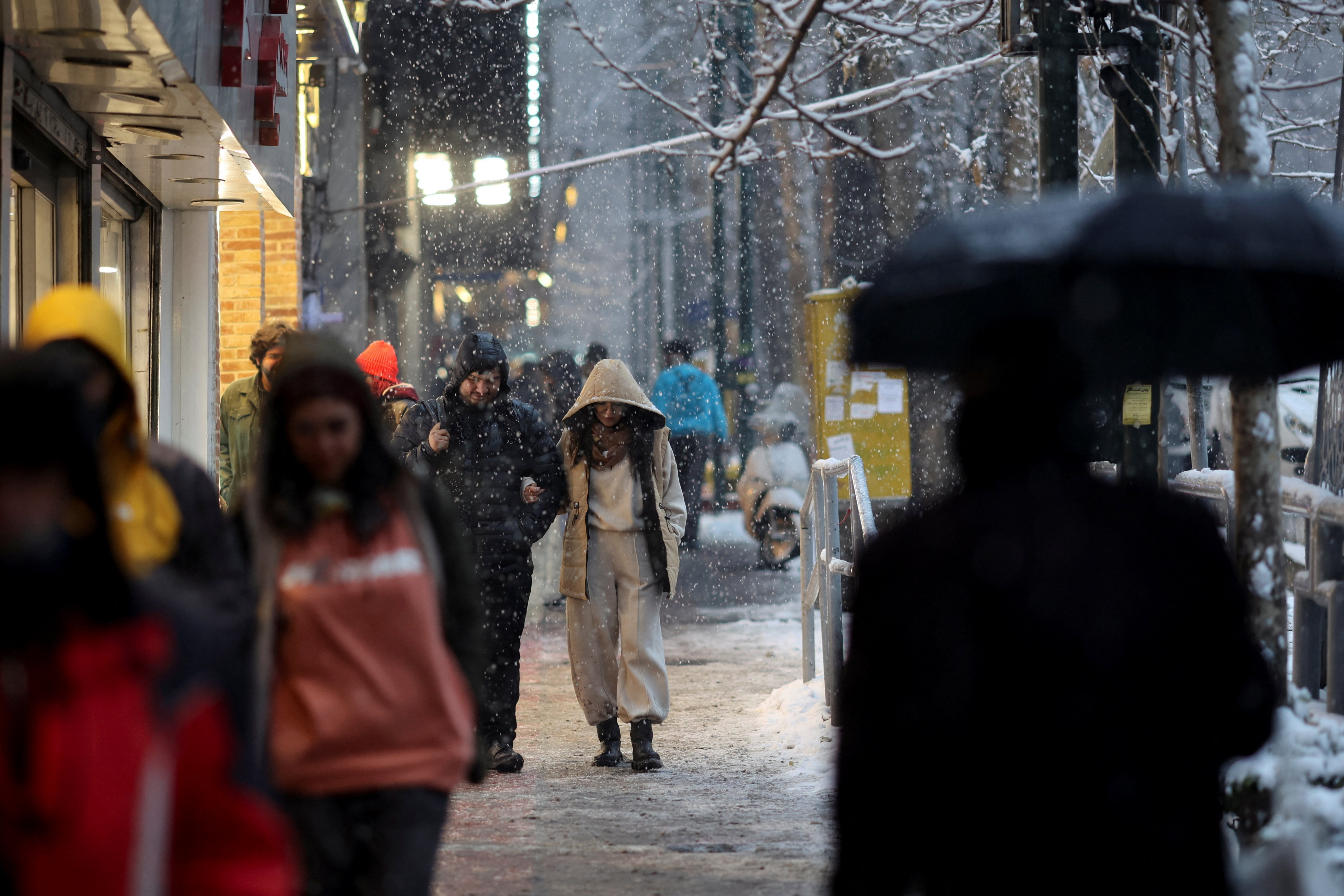 People walk along a street during snowfall in Tehran, Iran, January 23, 2026. Majid Asgaripour/WANA (West Asia News Agency) via REUTERS ATTENTION EDITORS - THIS PICTURE WAS PROVIDED BY A THIRD PARTY