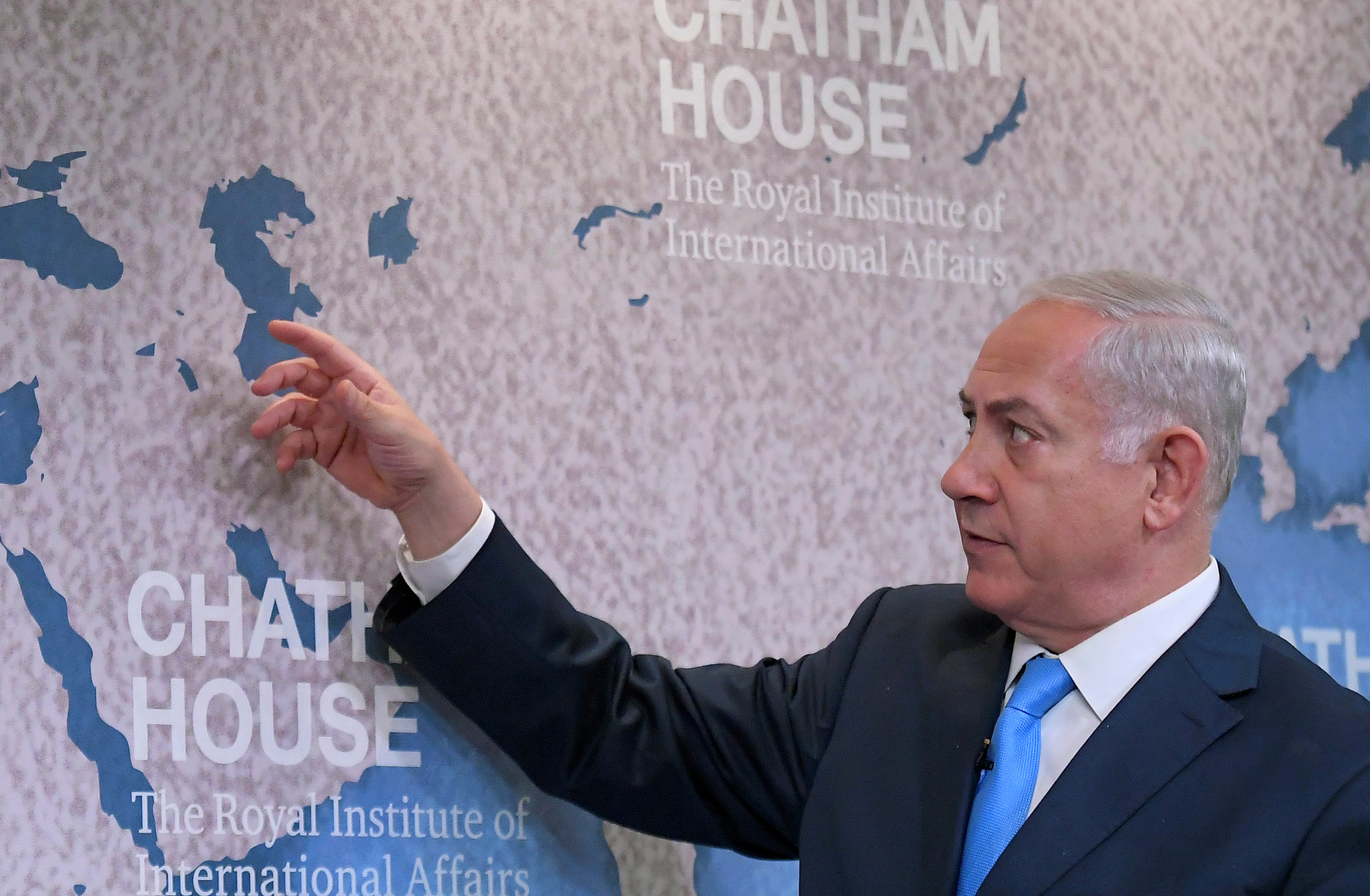 Netanyahu gestures towards a world map