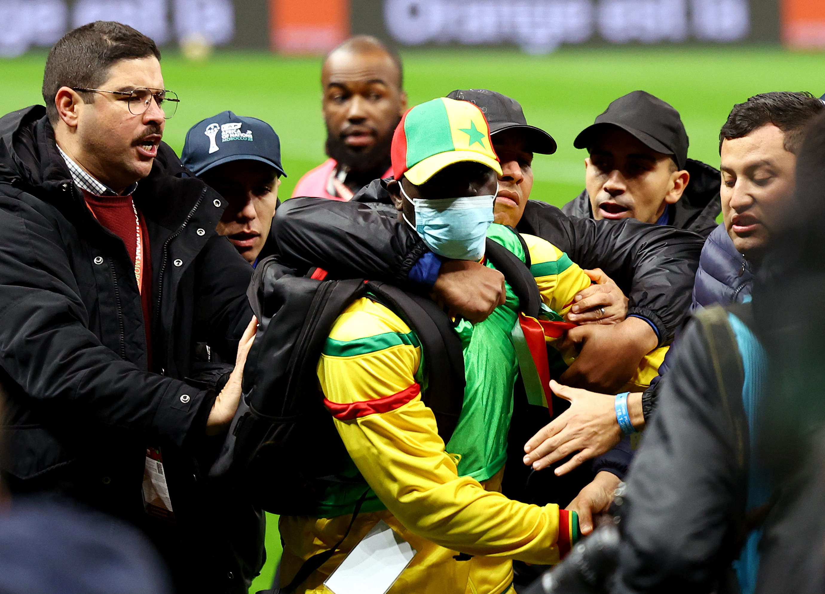 Security staff tackle a Senegal fan who invaded the pitch.