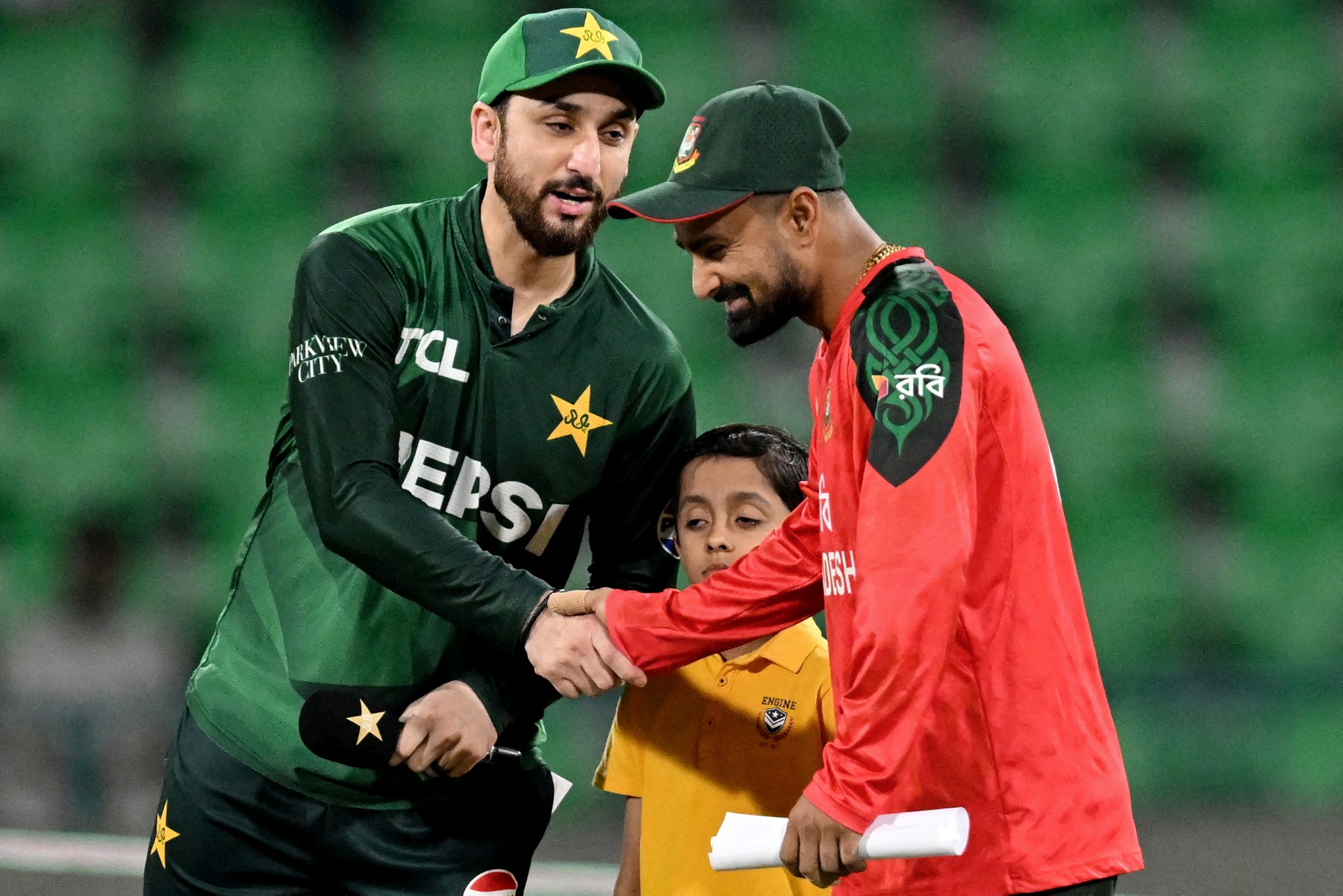 Pakistan's captain Salman Agha (L) shakes hands with his Bangladesh counterpart Litton Das during the toss before the start of the third and final Twenty20 international cricket match between Pakistan and Bangladesh at the Gaddafi Cricket Stadium in Lahore on June 1, 2025. (Photo by Aamir QURESHI / AFP)