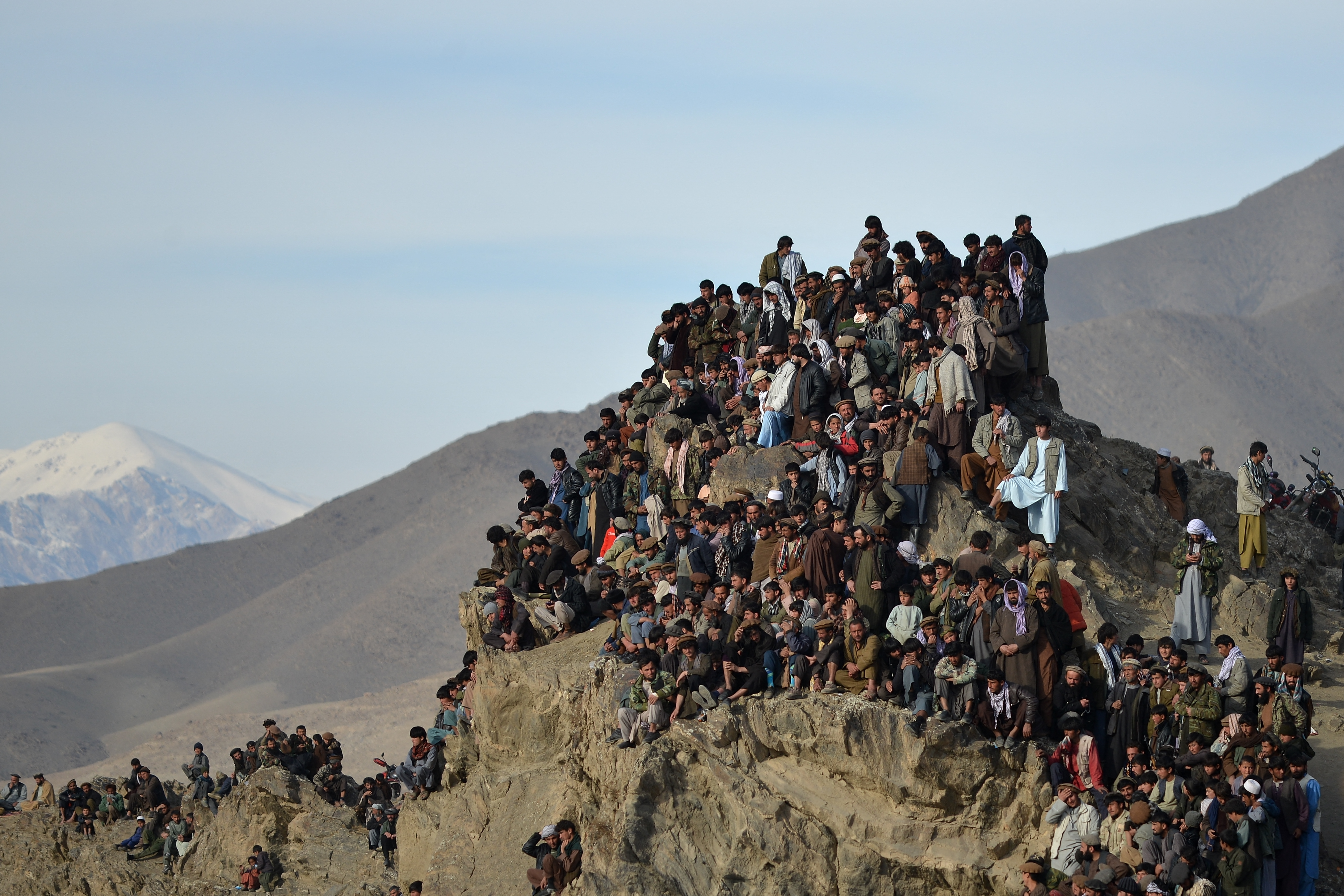 Afghans watch from a hilltop as horsemen compete during 'Buzkashi', a traditional Central Asian sport in the Jurm district of Badakhshan province