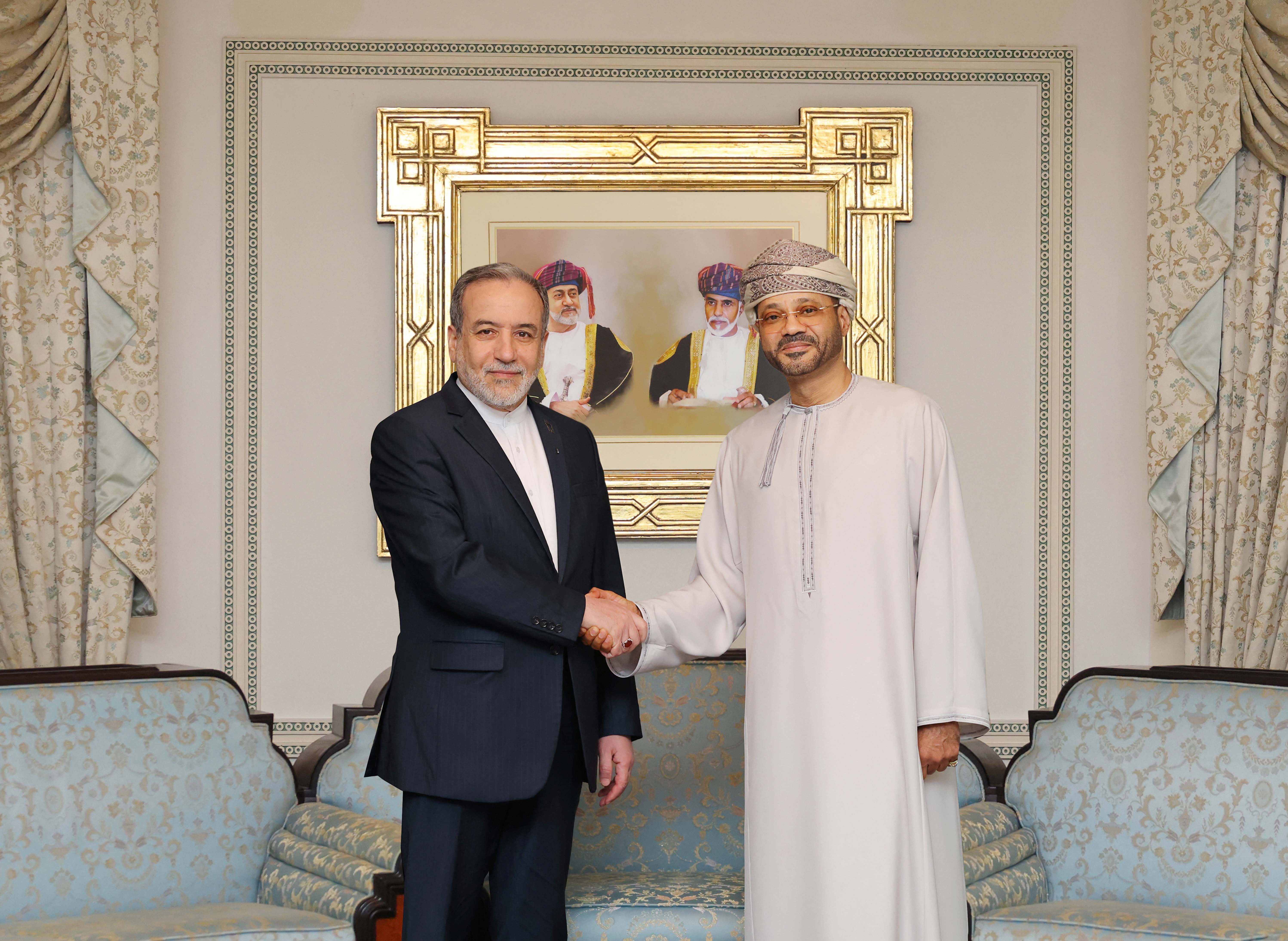 This handout photo released by the Omani Ministry of Foreign Affairs on February 6, 2026, shows Iranian Foreign Minister Abbas Araghchi (L) shaking hands with Oman’s Foreign Minister Badr bin Hamad al-Busaidi in Muscat. [Omani Foreign Ministry via AFP]
