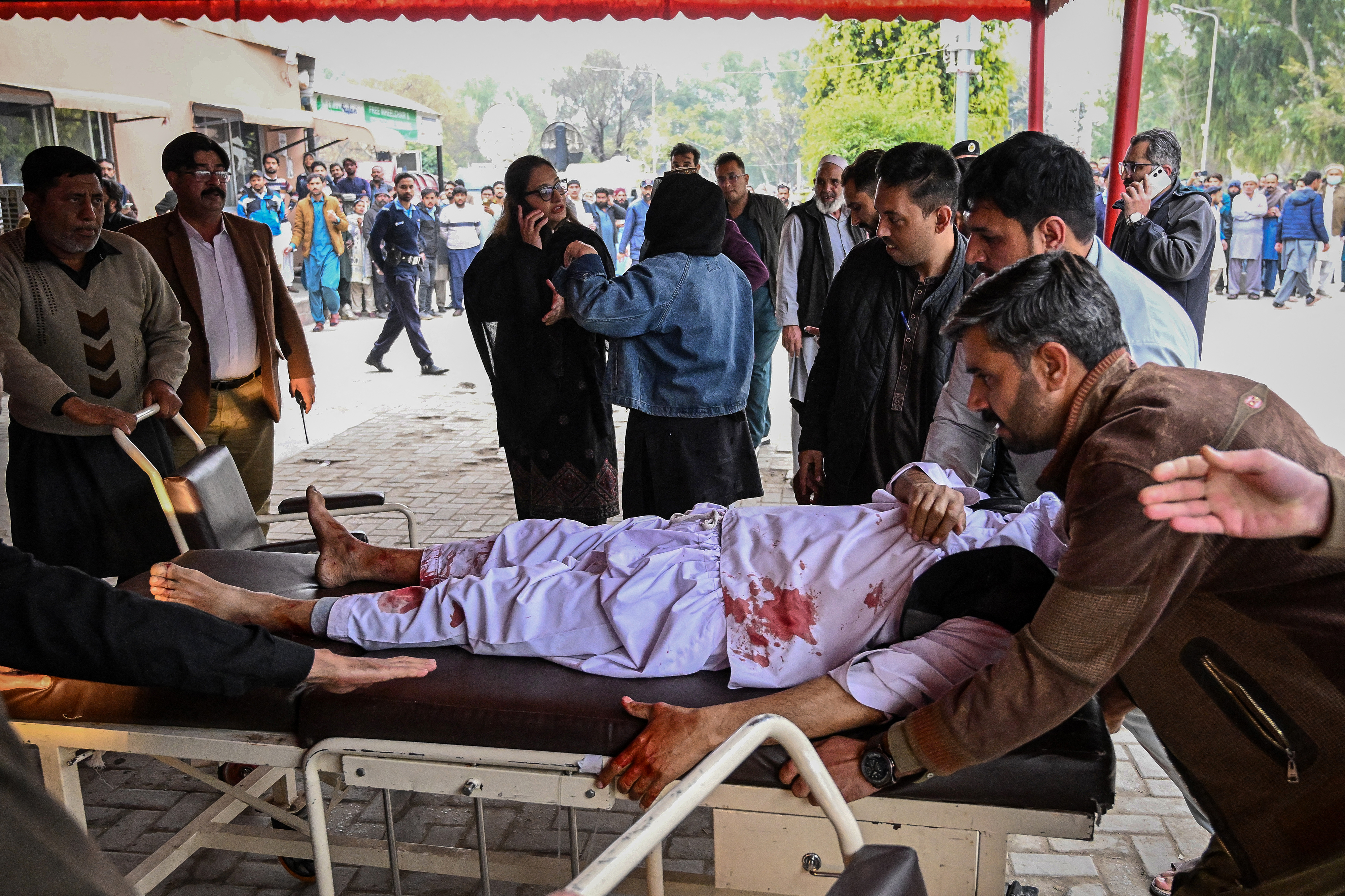 People shift an injured man to a hospital following an explosion at a mosque in Islamabad on February 6, 2026.