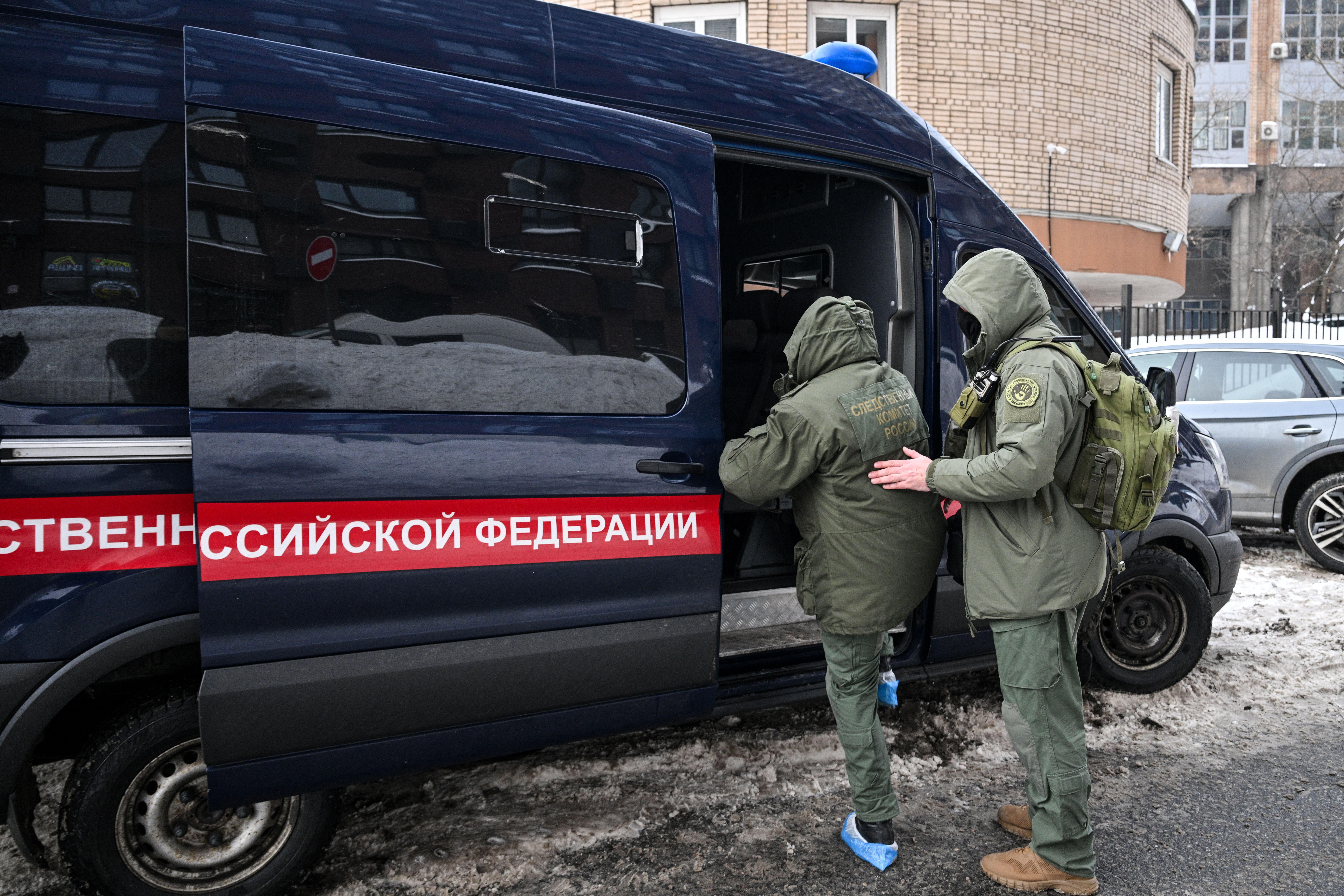 Investigators leave the scene of an assassination attempt on Russian Lieutenant General Vladimir Alekseyev in a high-rise residential building, in Moscow on February 6, 2026. A Russian general was shot in an apartment building in Moscow on Friday morning and rushed to hospital, officials said, in the latest apparent assassination attempt of a top Russian military figure. (Photo by Hector RETAMAL / AFP)