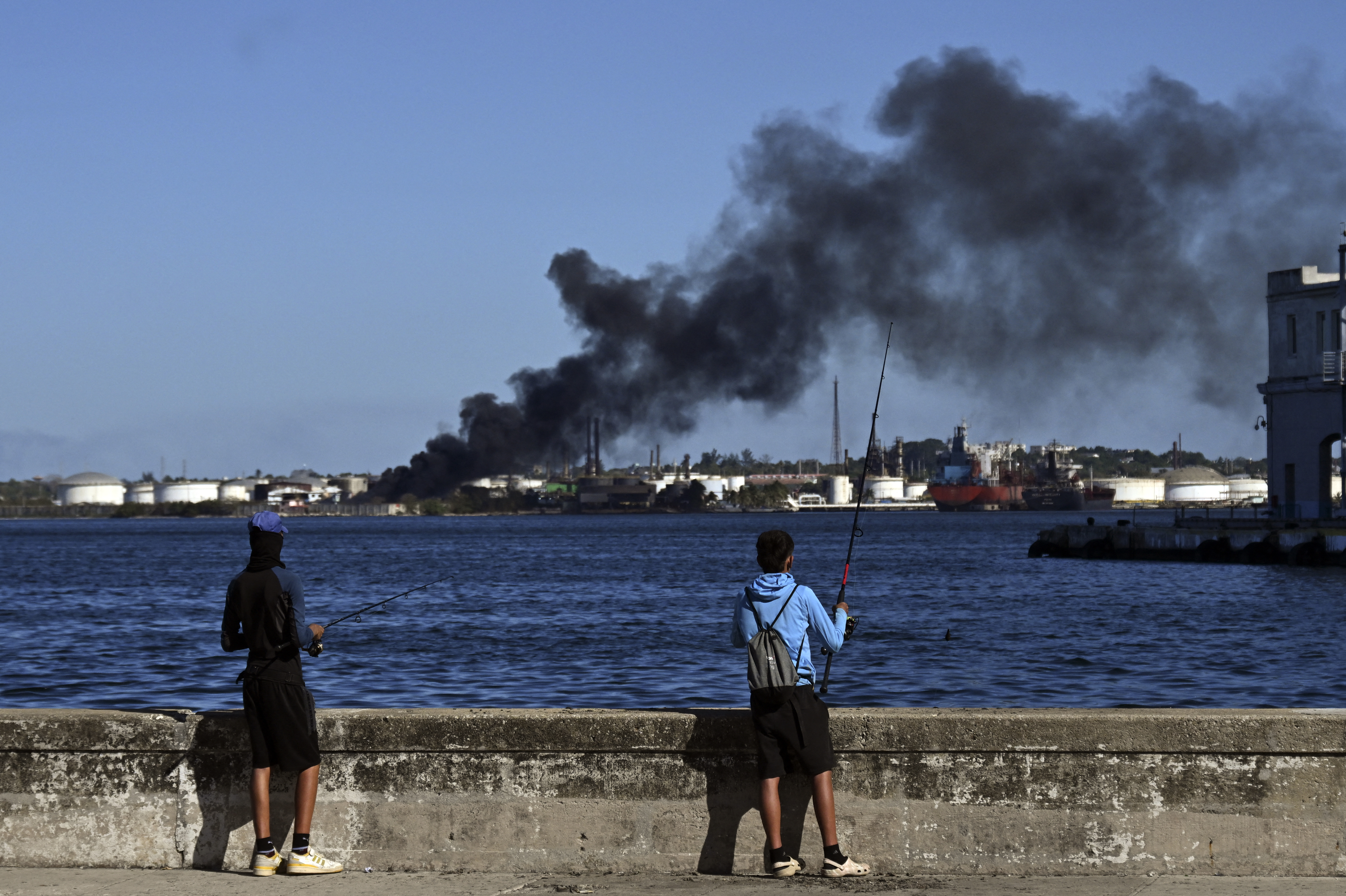 column of smoke rising from the Nico Lopez refinery in Havana Bay, though it was not known if the blaze was near the plants oil storage tanks. (Photo by YAMIL LAGE / AFP)