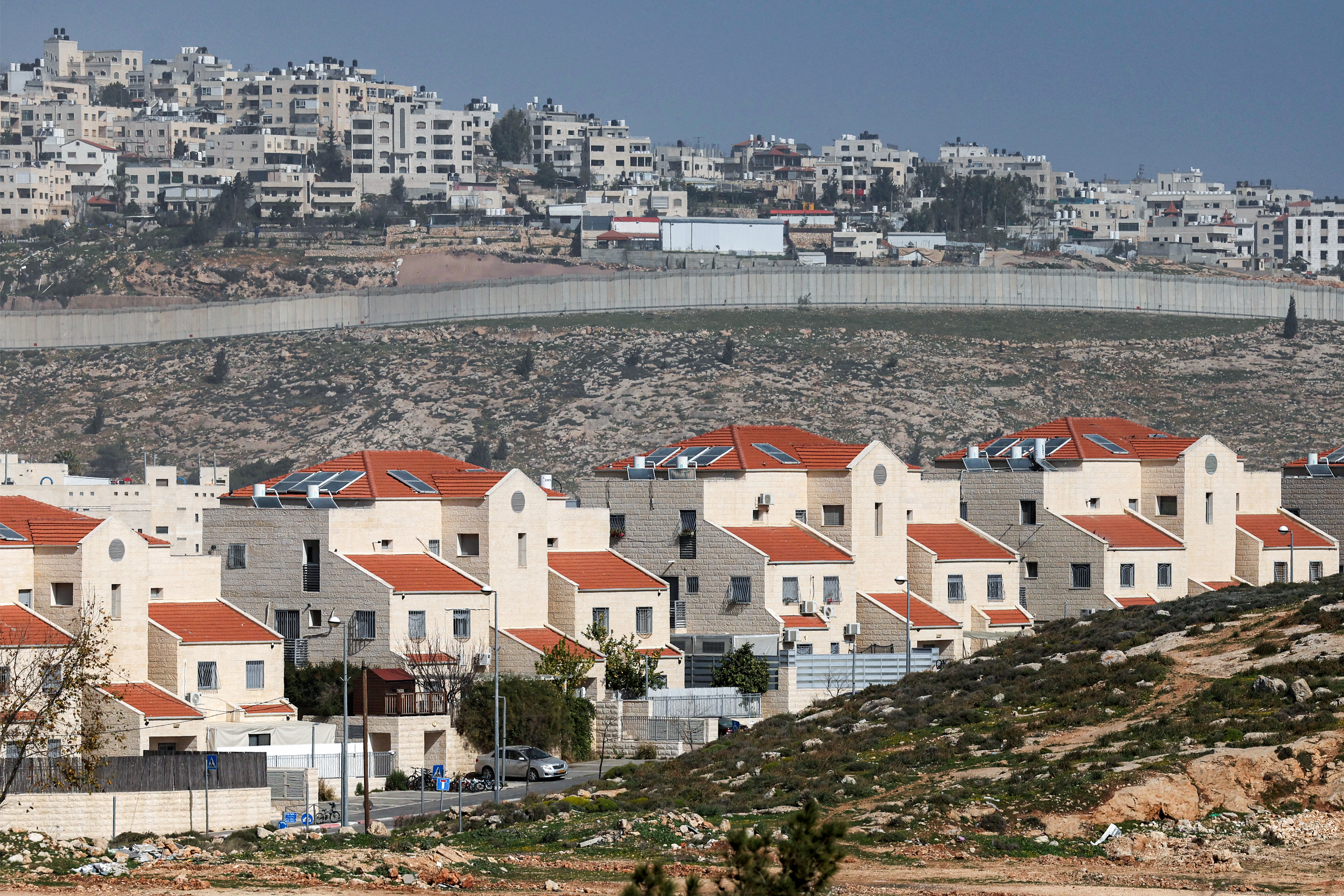 The Israeli settlement of Neve Yaakov (foreground) in the northern area of east Jerusalem and Israel's controversial barrier separating the Palestinian neighbourhood of al-Ram (background) are pictured in the occupied West Bank on February 16, 2026. (Photo by AHMAD GHARABLI / AFP)