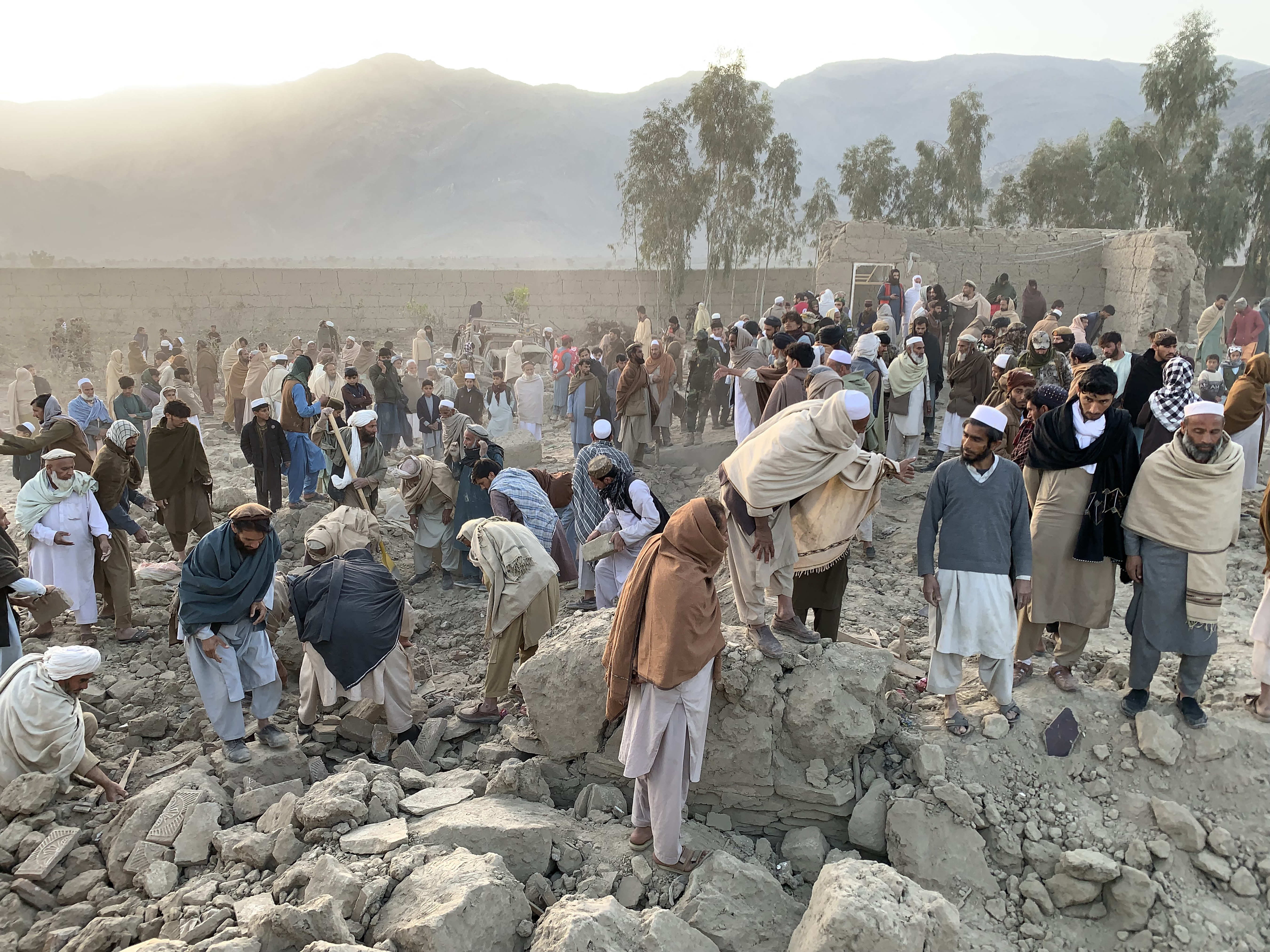 Afghan men search for victims after an overnight Pakistani airstrike hit a residential area in the Girdi Kas village