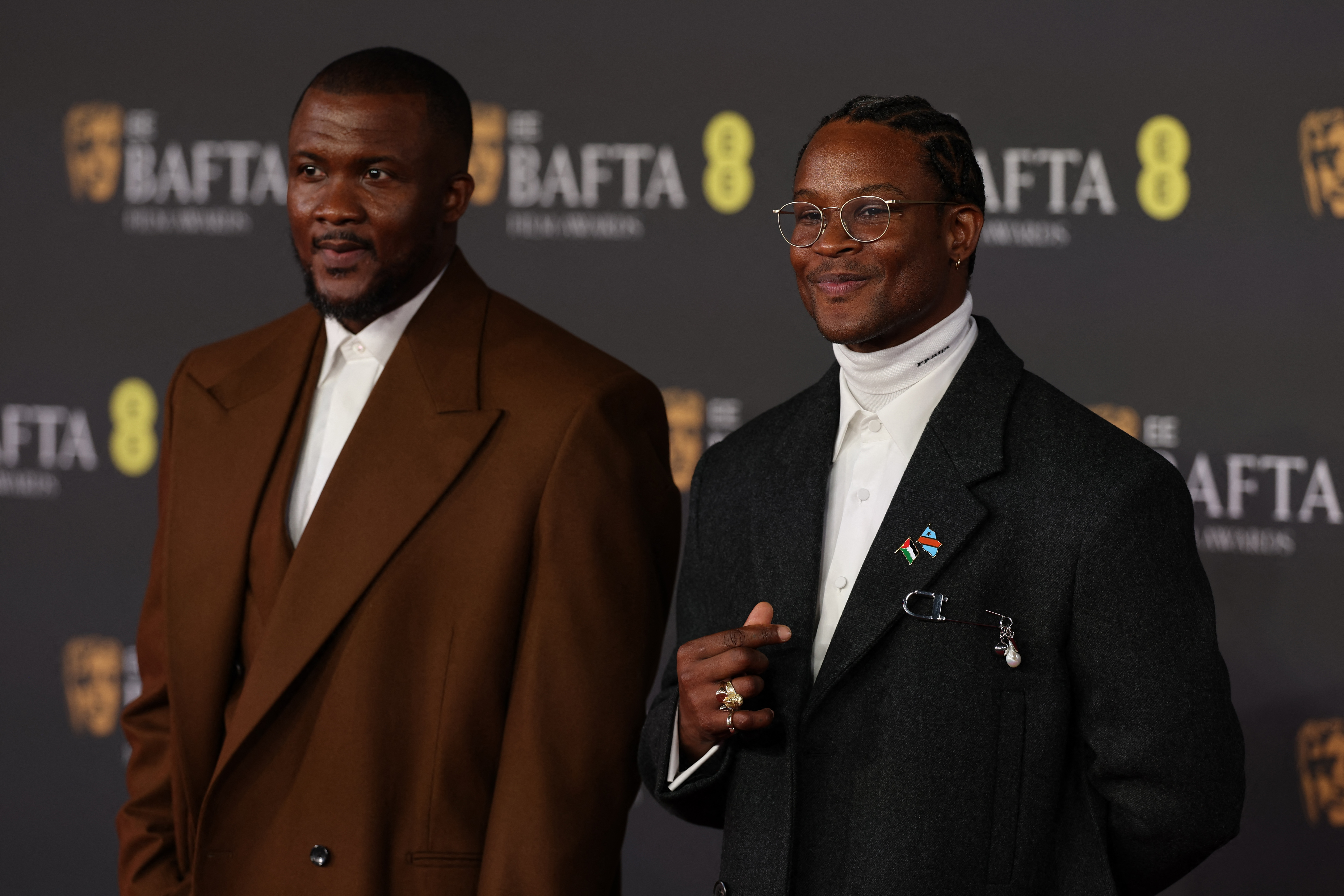 British writer Wales Davies and British-Nigerian director and writer Akinola Davies Jr. poses on the red carpet upon arrival at the BAFTA British Academy Film Awards at the Royal Festival Hall, Southbank Centre, in London, on February 22, 2026. (Photo by Adrian Dennis / AFP)