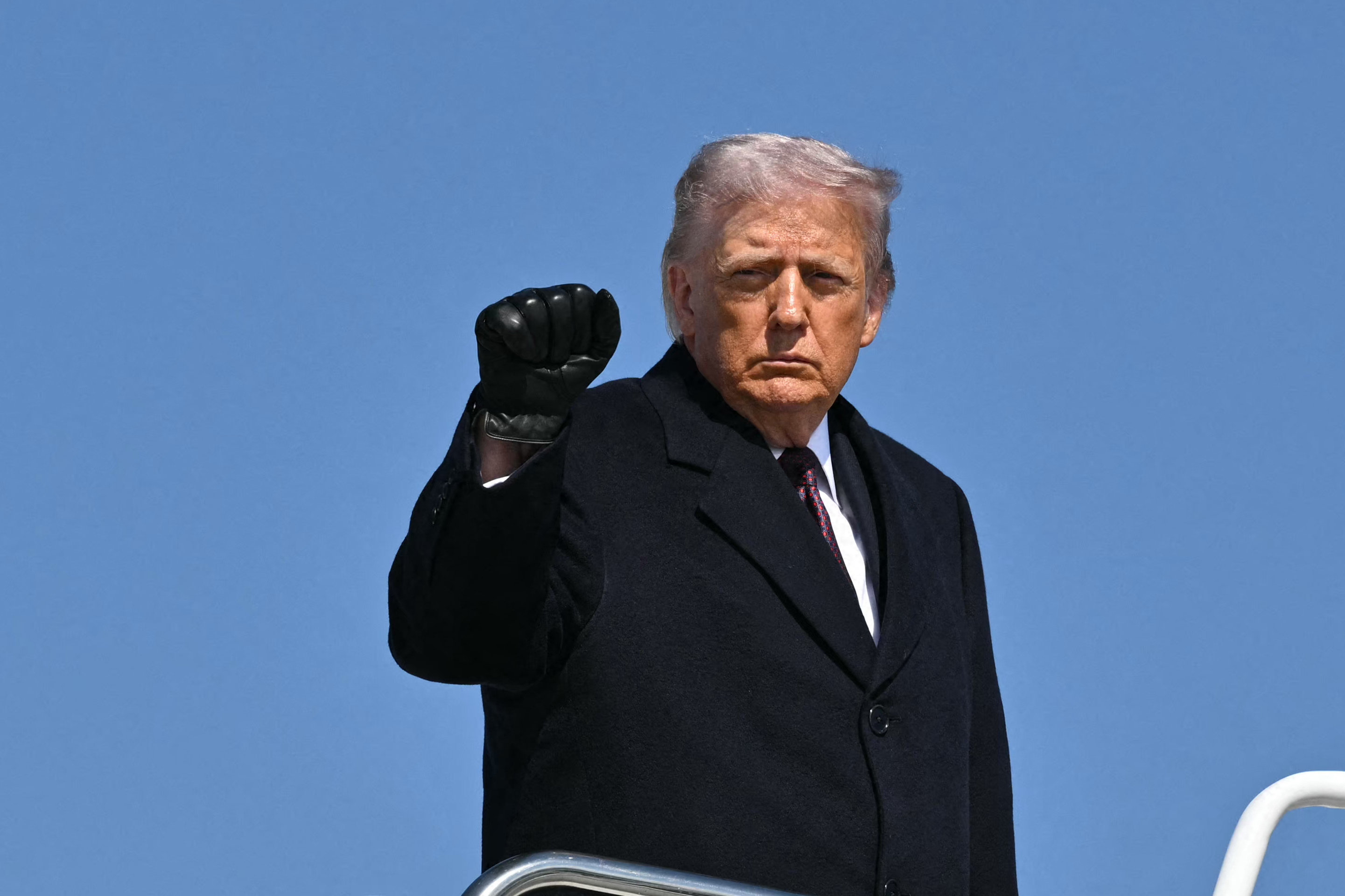 US President Donald Trump pumps his fist as he boards Air Force One