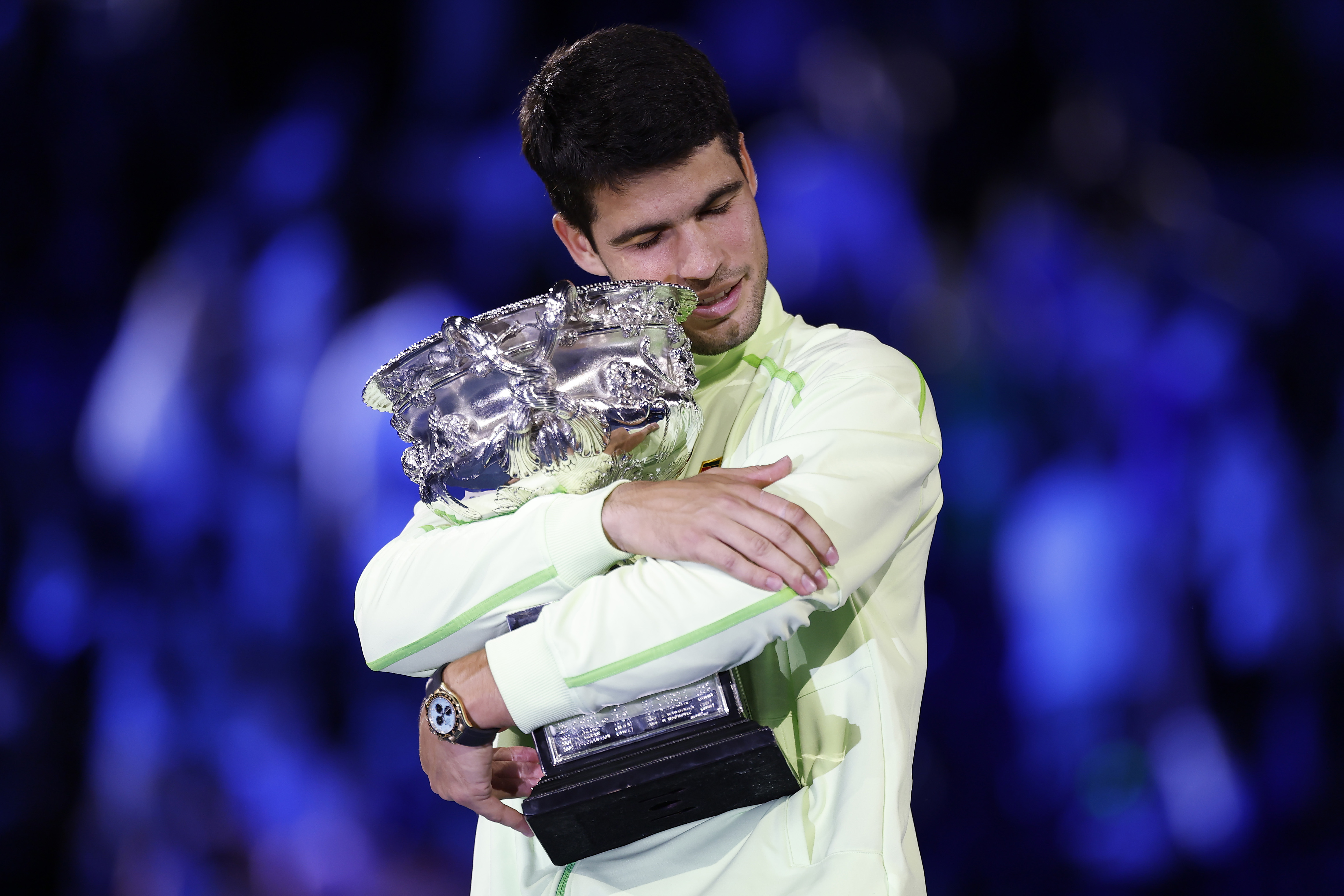 MELBOURNE, AUSTRALIA - FEBRUARY 01: Carlos Alcaraz of Spain hugs the Norman Brookes Challenge Cup at the presentation ceremony after his victory in the Men's Singles Final against Novak Djokovic of Serbia during day 15 of the 2026 Australian Open at Melbourne Park on February 01, 2026 in Melbourne, Australia. (Photo by Darrian Traynor/Getty Images)