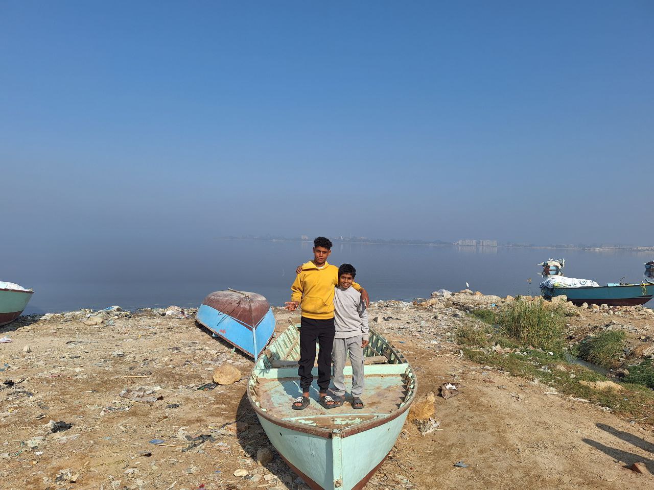 Children stand on boat left on dry land