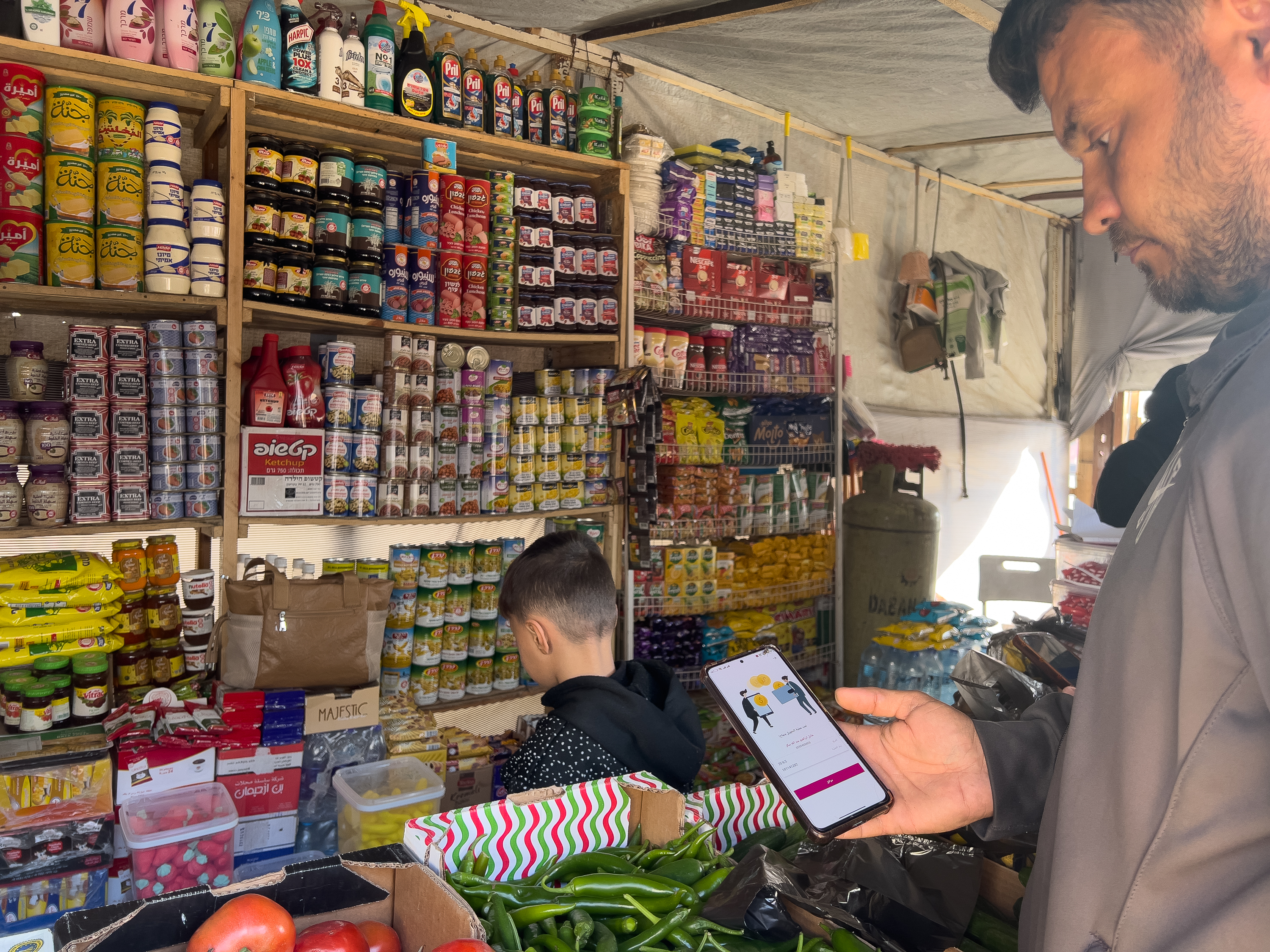 A customer pays for groceries using bank account transactions [Ola al-Asi/ Al Jazeera]