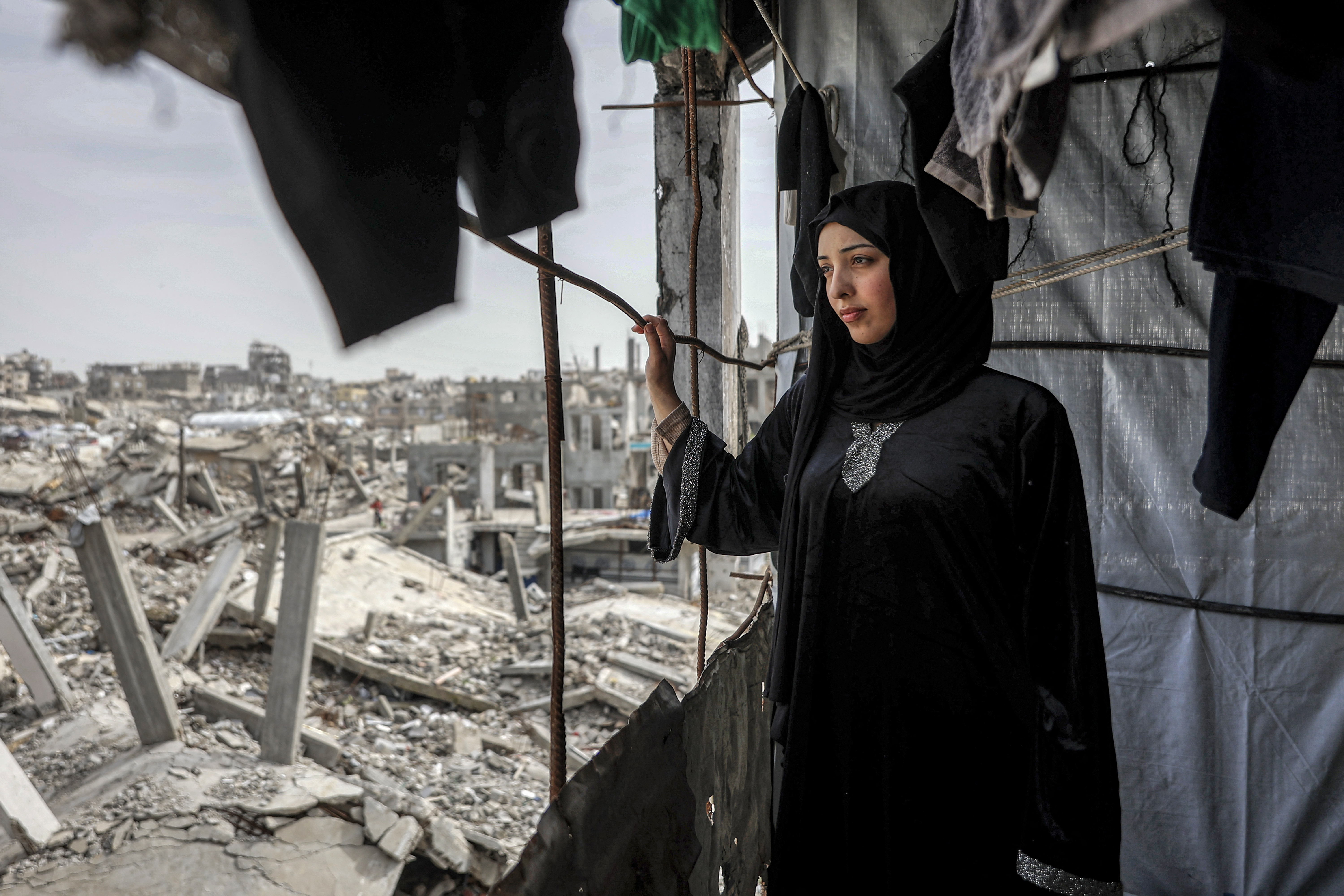Etedal Rayyan (29), who recently returned back to Gaza from Egypt through the Rafah border crossing, looks out the window of her heavily-damaged house in the Jabalia camp for Palestinian refugees in the northern Gaza Strip on February 8, 2026.