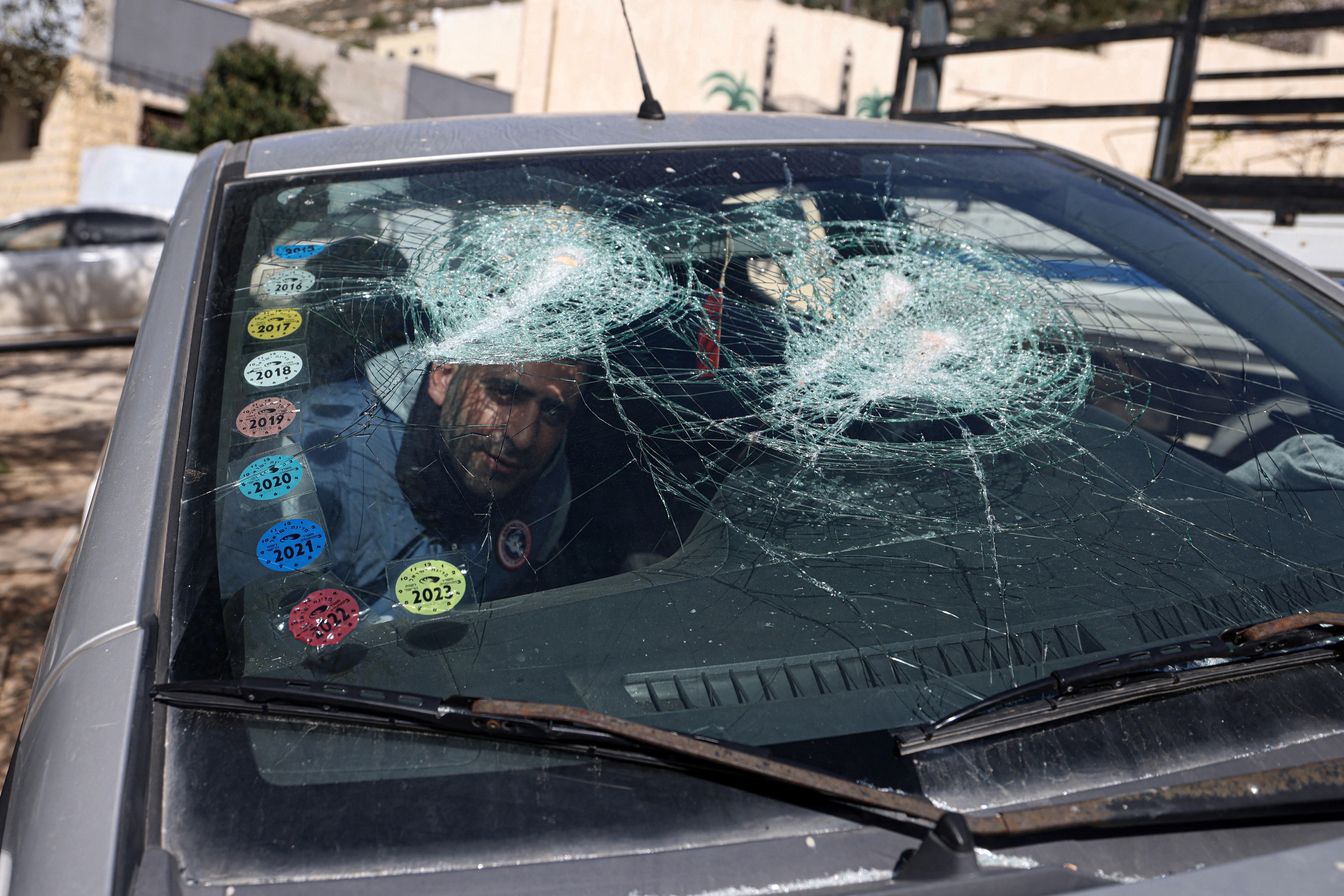 A Palestinian man inspects one of several cars vandalised by Jewish settlers, who entered the Palestinian village of Telfit, south of the Israeli-occupied West Bank city of Nablus on February 13, 2026.