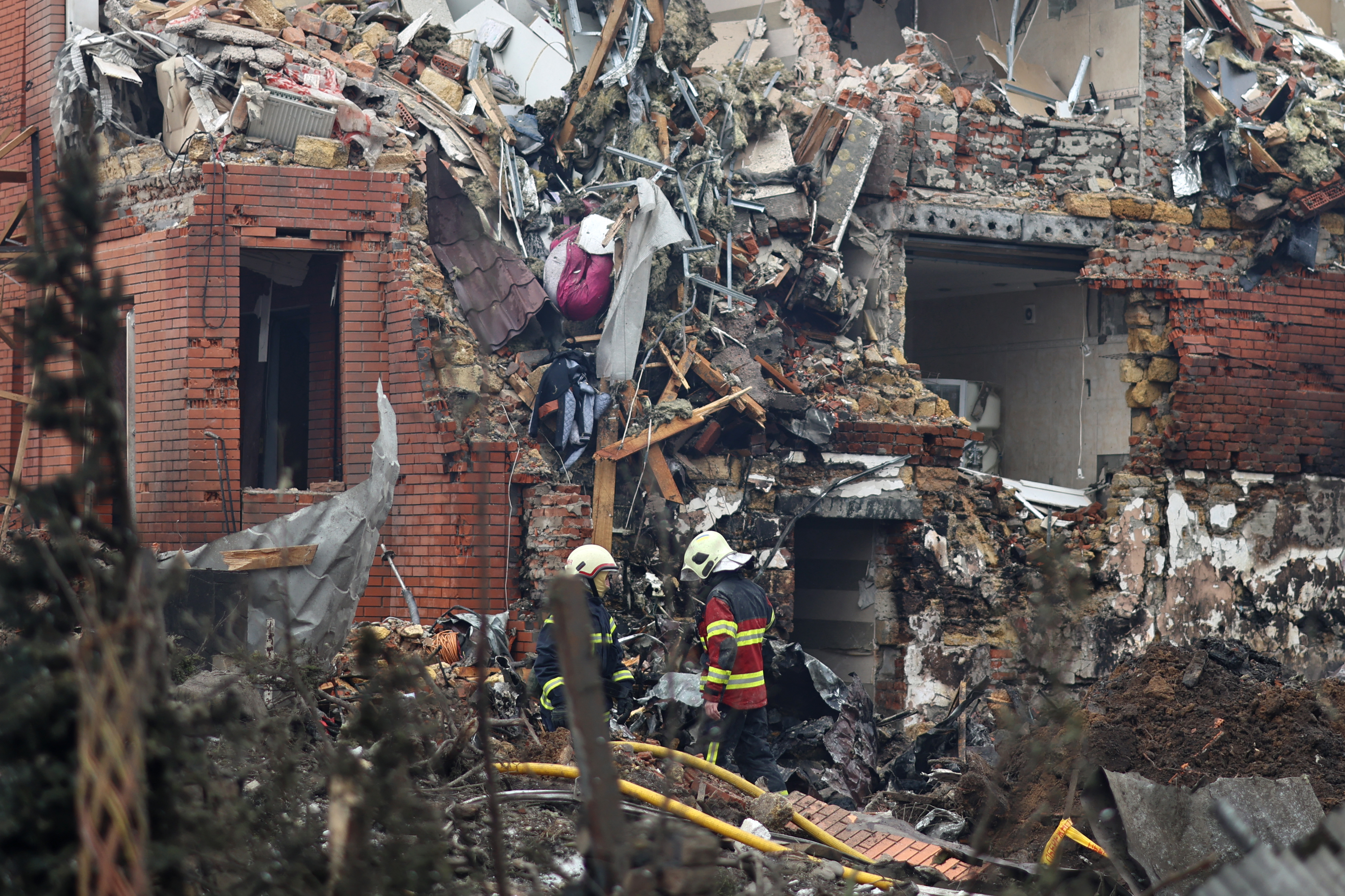 Ukrainian rescuers work at the site of a heavily damaged house following an air attack in Sofiivska Borshchagivka, Kyiv region on February 22, 2026, amid the Russian invasion of Ukraine.